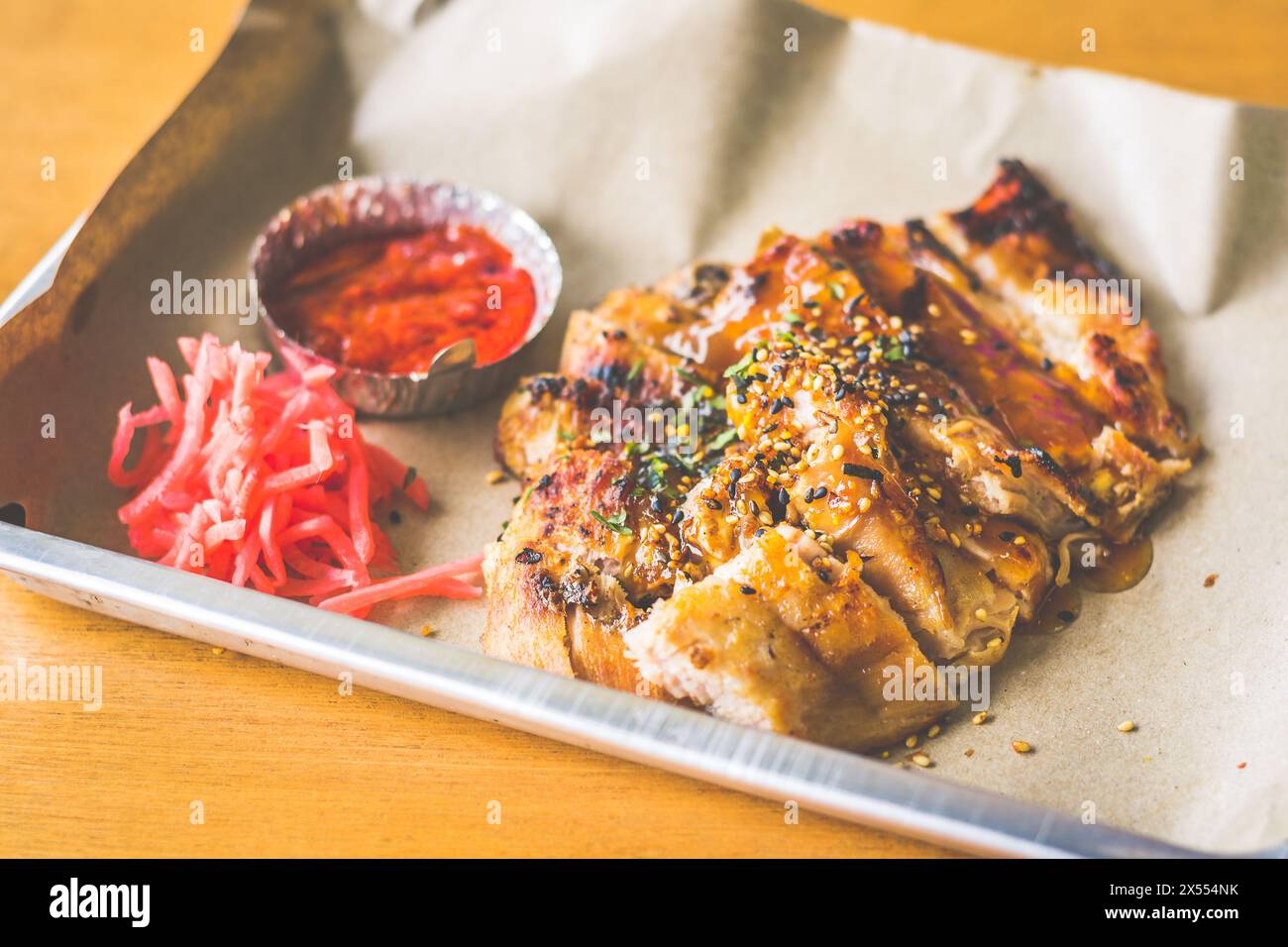 Une joue de porc grillée à la carte servie avec du gingembre mariné et de la sauce piment Banque D'Images