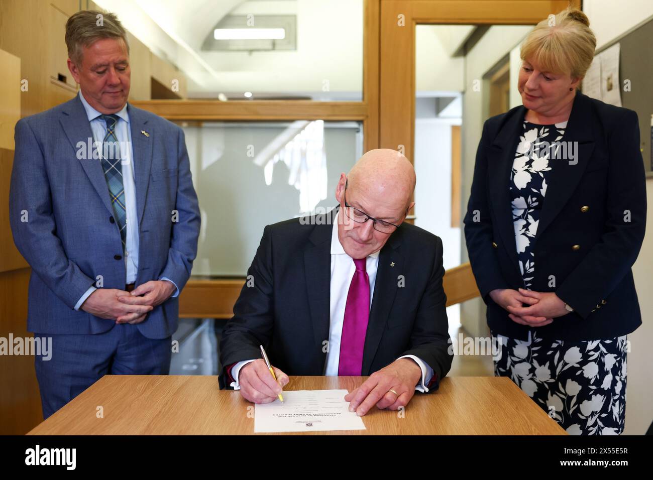 John Swinney, nouveau chef du Parti national écossais (SNP), signe sa lettre de nomination pour devenir premier ministre, avec ses proposants Shona Robinson (à droite) et Keith Brown, au Parlement écossais à Édimbourg. Date de la photo : mardi 7 mai 2024. Banque D'Images