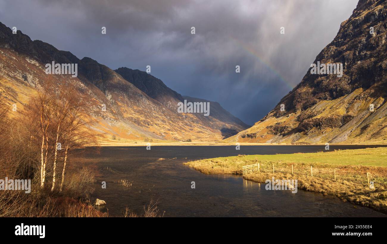 Arc-en-ciel au-dessus du Loch Achtriochtan dans les Highlands écossais, Glencoe, Écosse. Printemps (mars) 2024. Banque D'Images