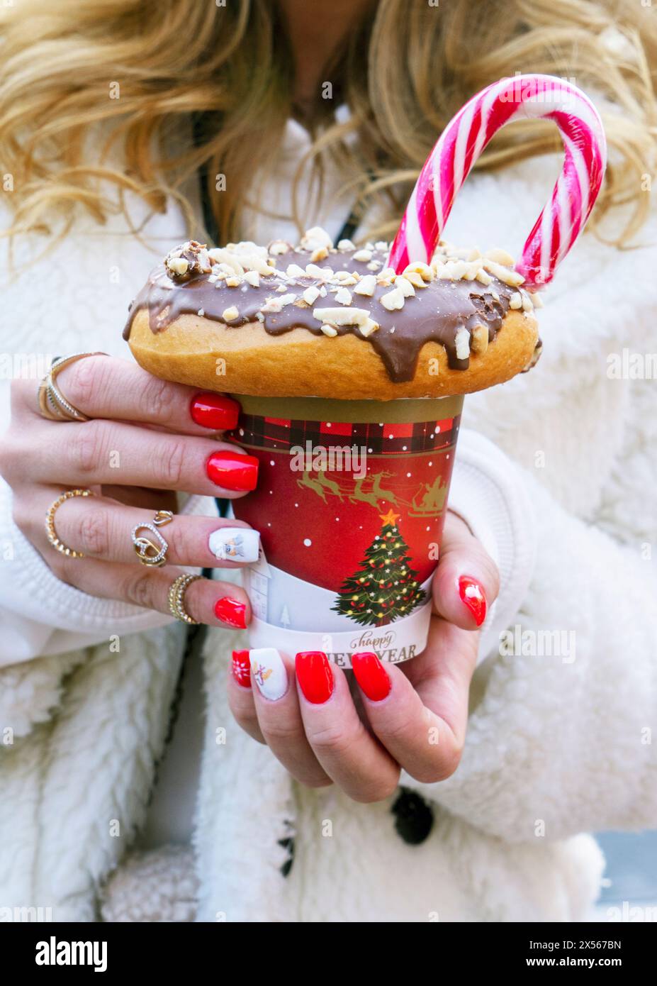 fille tenant un milkshake avec des beignets et d'autres bonbons dans un pot Banque D'Images