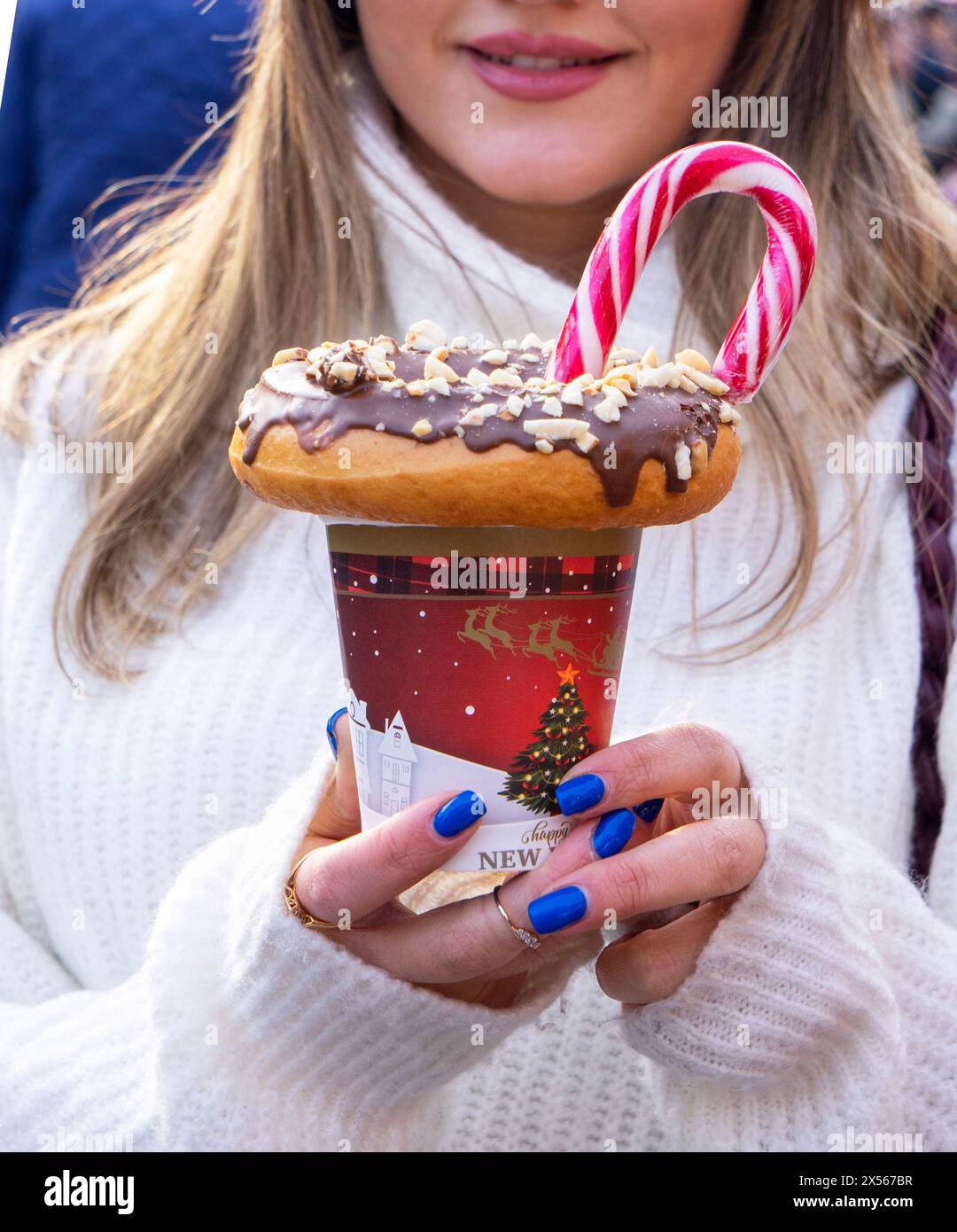 fille tenant un milkshake avec des beignets et d'autres bonbons dans un pot Banque D'Images