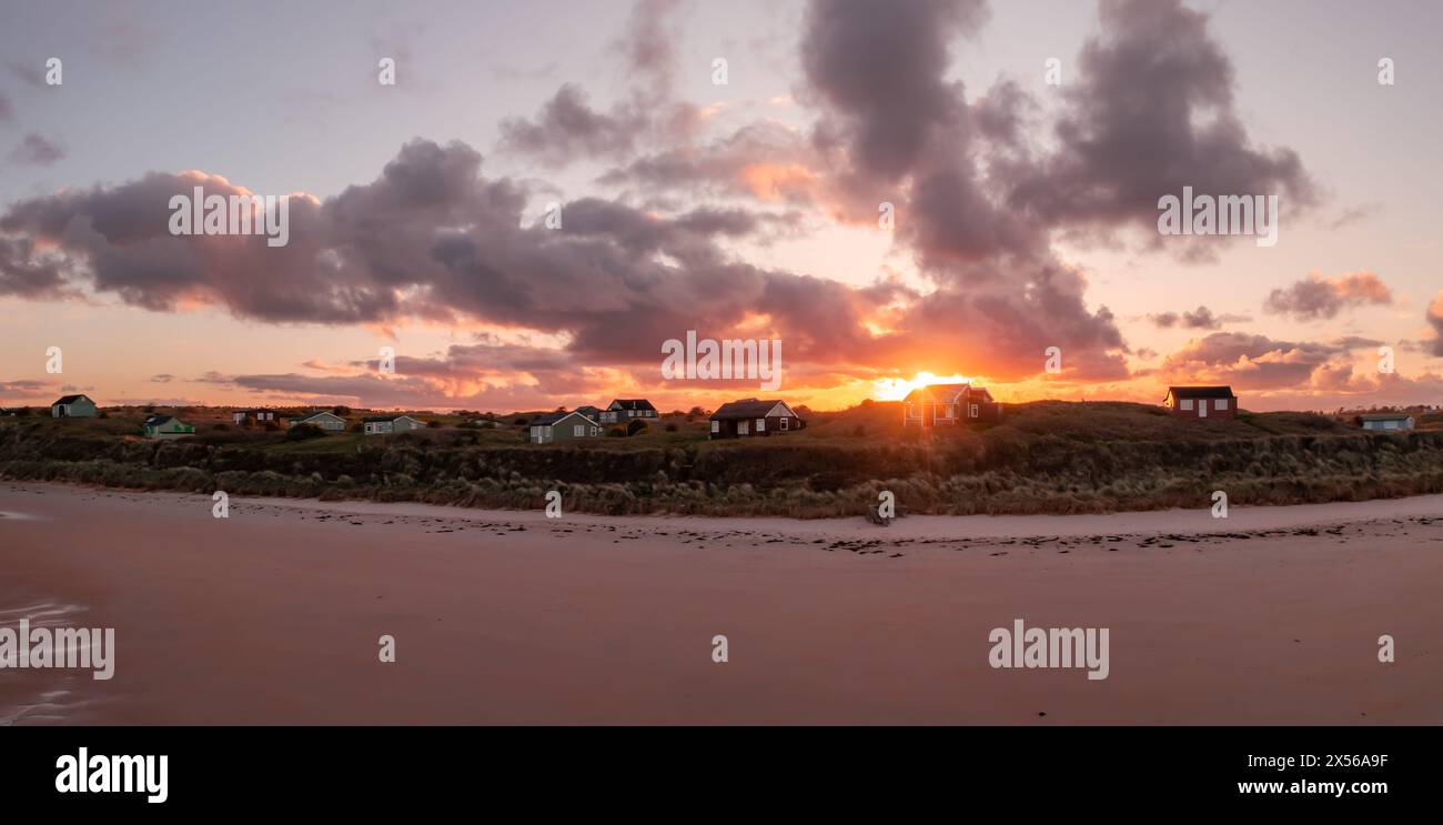 Cabanes de plage éloignées avec vue sur la mer sur les dunes de sable de Northumbrian surplombant la plage d'Embleton Bay au coucher du soleil Banque D'Images