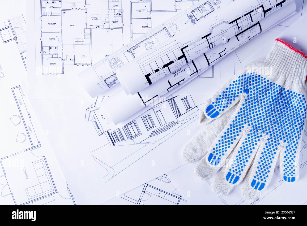 Outils du constructeur sur le schéma de la maison. Préparation à la construction d'une maison. Les gants et les plans de construction. Banque D'Images