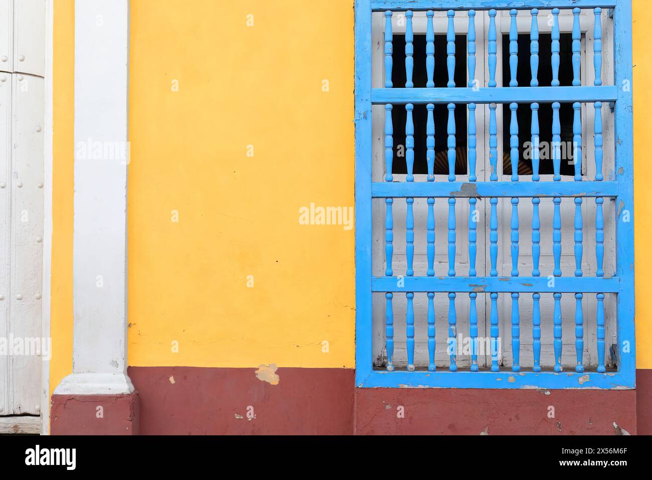 246 mur coloriste de maison coloniale montrant la fenêtre de grille habituelle, à volets en bois, en forme de porte sur une façade bleu-jaune-marron-blanc. Trinidad-Cuba. Banque D'Images