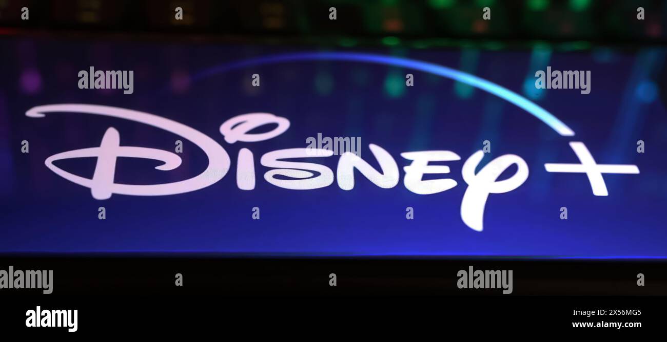 Viersen, Allemagne - 1er mai. 2024 : gros plan de smartphone avec lettrage logo de Disney plus canal de service de streaming sur clavier d'ordinateur Banque D'Images