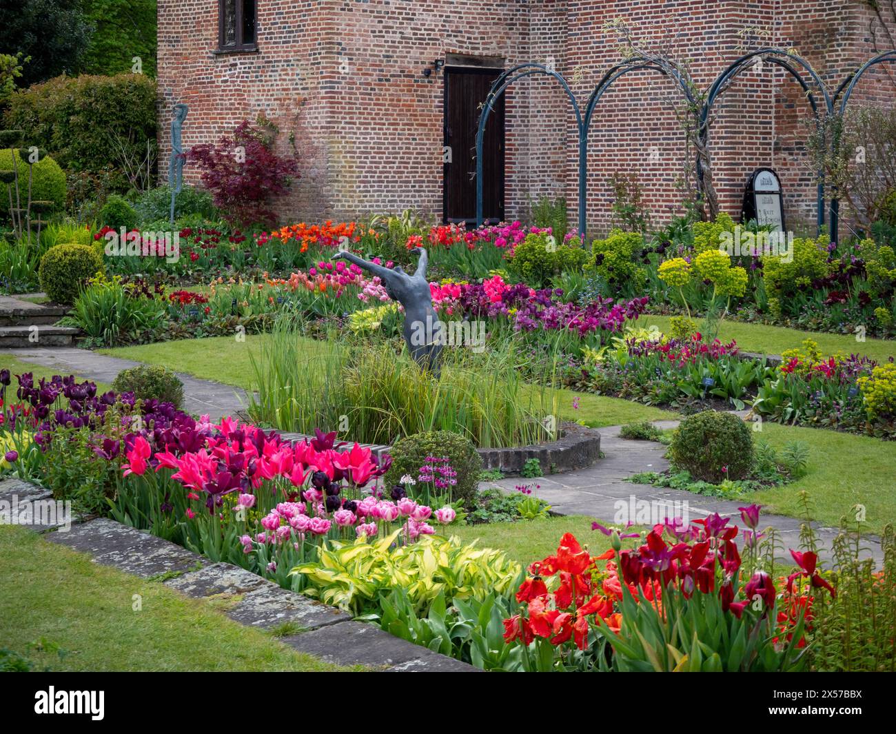 Chenies Manor jardin encastré avec tulipes colorées en pleine floraison. Fleurs oranges, roses, violettes en fin d'après-midi soleil. Banque D'Images
