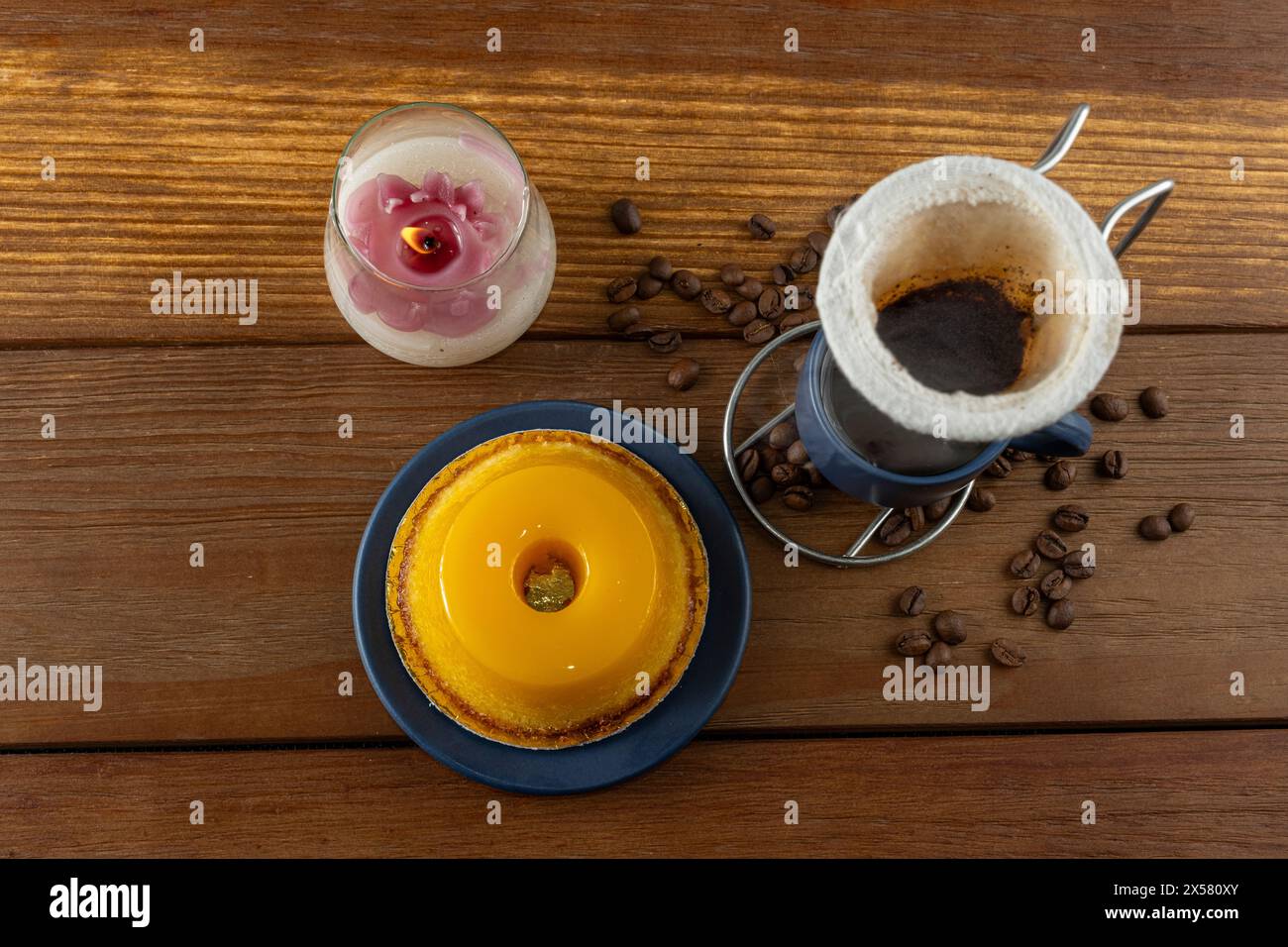 Petit quindim, sucré traditionnel brésilien, à côté d'une tasse de café et d'une bougie 3. Banque D'Images