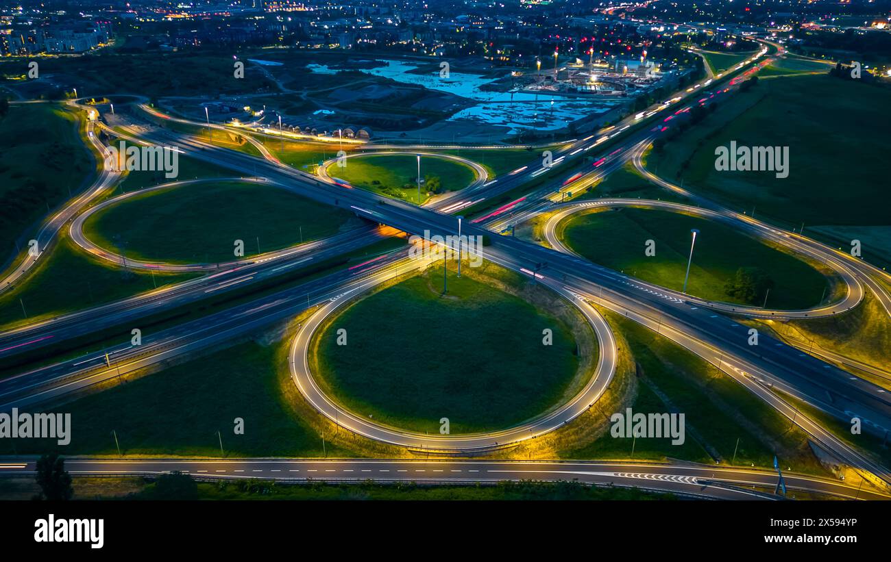 Route et rond-point, autoroute à plusieurs niveaux de jonction la nuit. Vue de dessus de l'autoroute. A51 Tangenziale est di Milano, Italie Banque D'Images