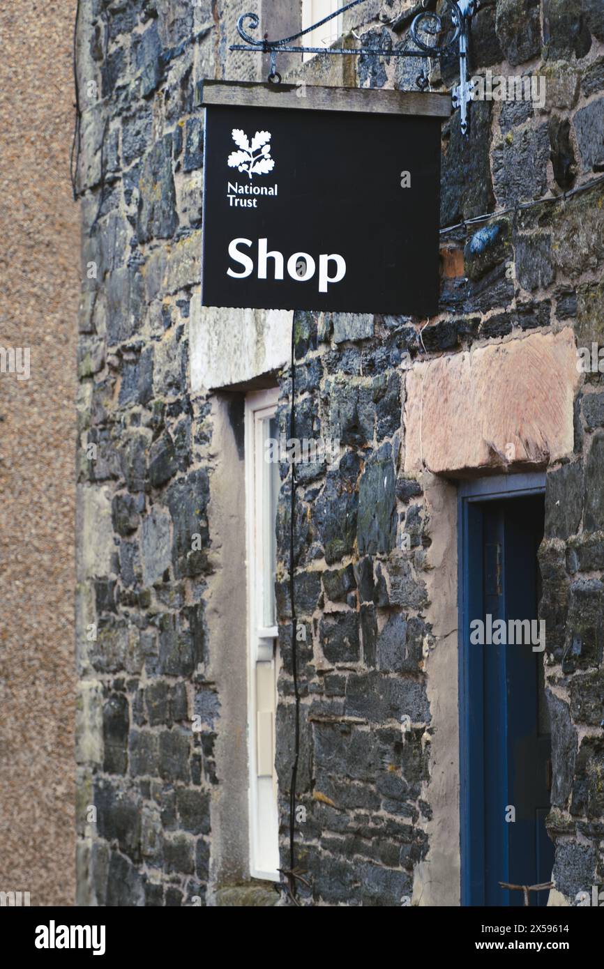HOLY ISLAND, NORTHUMBERLAND, ROYAUME-UNI - 25 AVRIL 2024. Une enseigne de magasin de la National Trust sur un magasin vendant des articles à des acheteurs sur un site historique Banque D'Images
