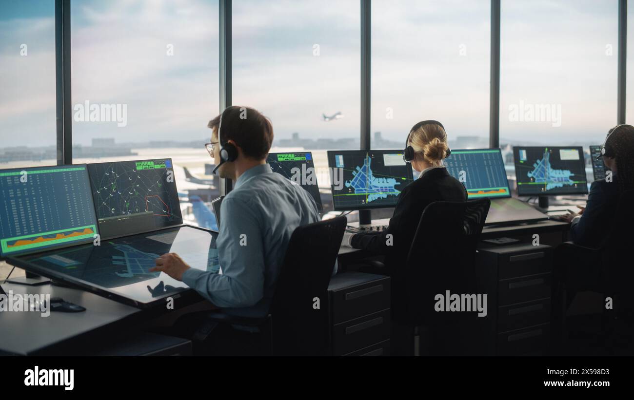 Équipe diversifiée de contrôle du trafic aérien travaillant dans une tour d'aéroport moderne. La salle de bureau est pleine d'écrans d'ordinateur de bureau avec écrans de navigation, données radar de vol d'avion pour les contrôleurs. Banque D'Images