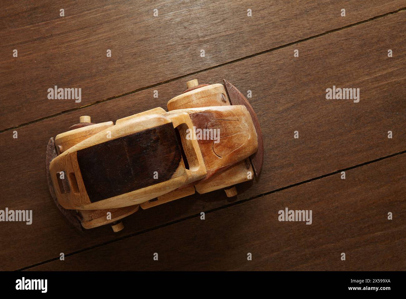 Vue de dessus d'une voiture jouet en bois sur une table avec une texture en bois Banque D'Images