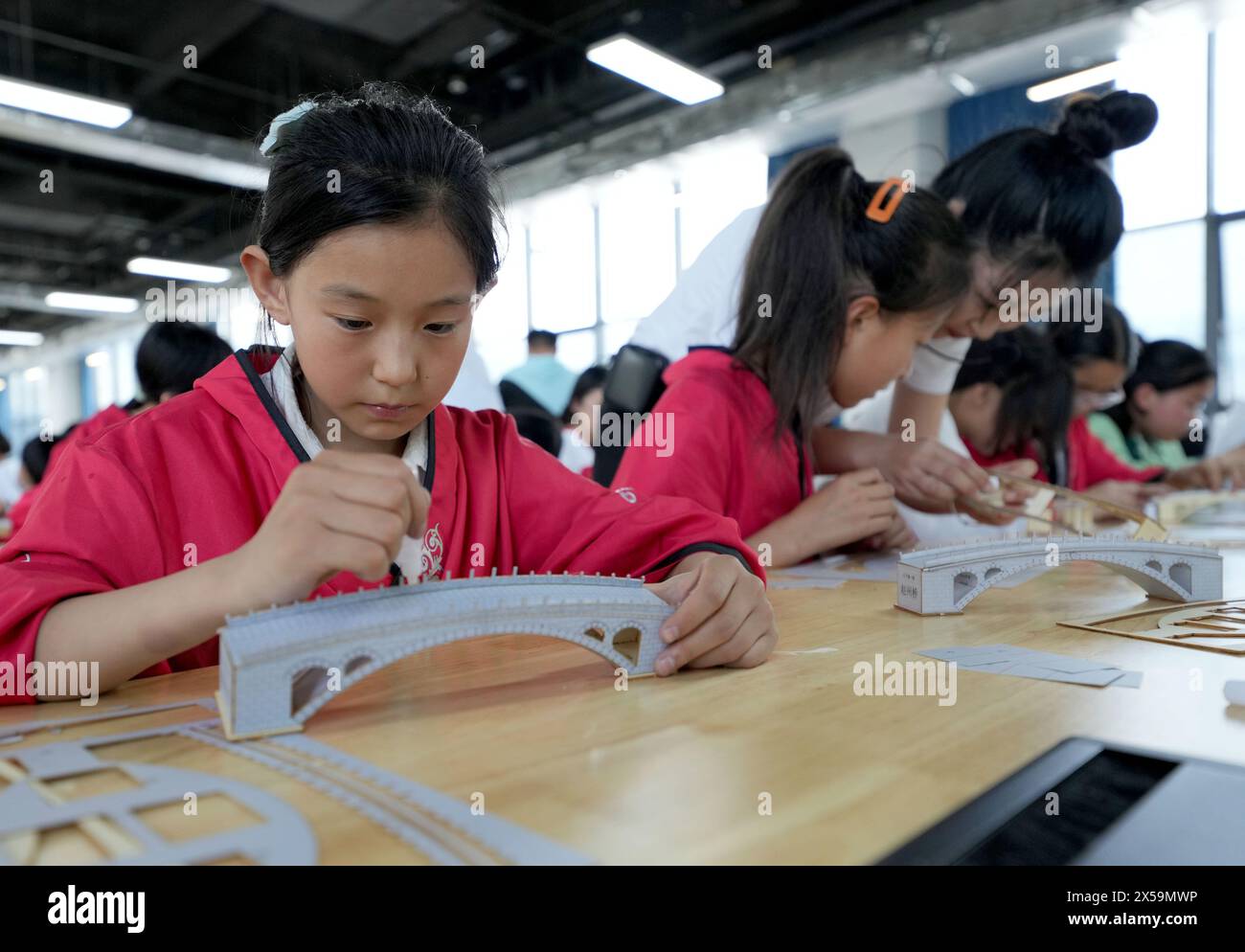 (240508) -- PÉKIN, 8 mai 2024 (Xinhua) -- des élèves font des maquettes du pont de Zhaozhou dans une école primaire du comté de Zhaoxian, dans la province du Hebei, au nord de la Chine, le 25 avril 2024. Construit sous la dynastie Sui (581-618), le pont de Zhaozhou vieux de 1 400 ans surplombe la rivière Xiaohe dans le comté de Zhaoxian, province du Hebei. C'est le plus ancien pont à arche unique du monde. La combinaison de l'emplacement, de la conception et de l'excellente construction sont les principales raisons pour lesquelles le pont a résisté aux tremblements de terre, aux inondations et à la guerre pendant 1 400 ans. Outre des monuments célèbres dans le monde entier tels que la Cité interdite et la Grande Muraille, le Banque D'Images