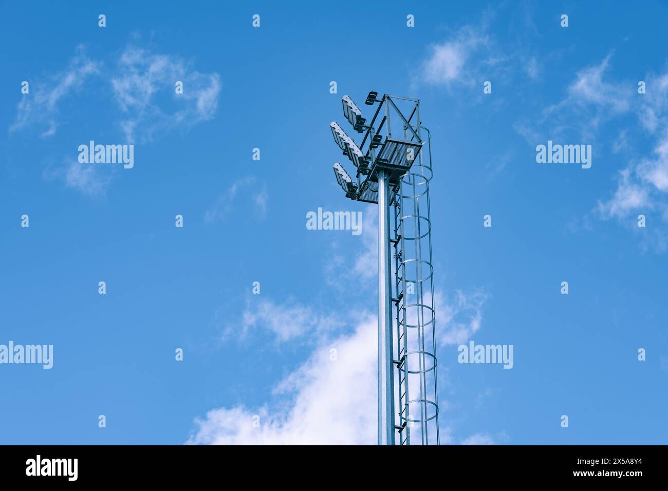 Un site cellulaire imposant se dresse haut contre un ciel bleu serein, parsemé de légères formations nuageuses. Banque D'Images
