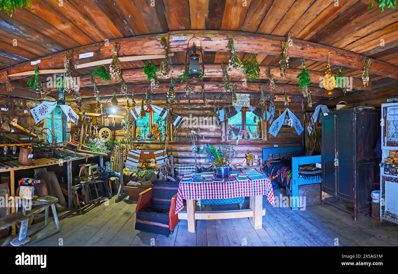 YABLUNYTSYA, UKRAINE - 24 JUILLET 2021 : intérieur de la maison de Hutsul molfar (sorcier folklorique) avec meubles en bois, herbes, ustensiles de cuisine et rushnyk décoratif Banque D'Images