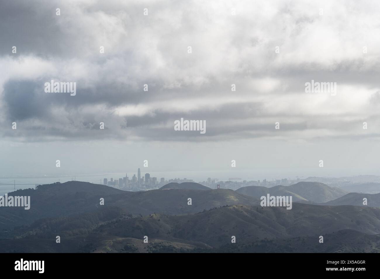 Vue lointaine de la skyline de San Francisco, vue à travers le brouillard et la brume depuis le sommet d'une montagne verte printanière dans les Marin Headlands, au nord de Cali Banque D'Images