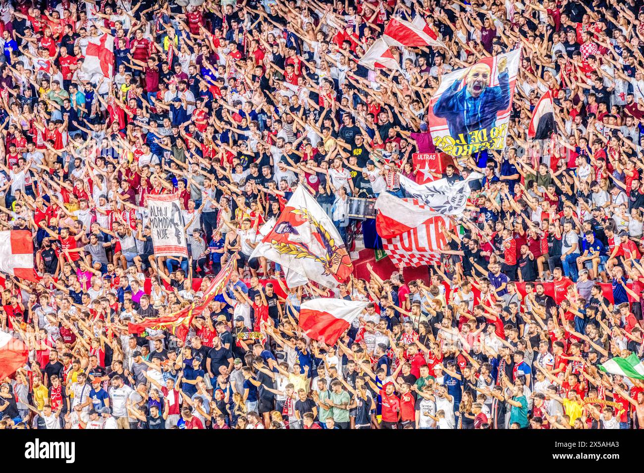 Foule enthousiaste de supporters du Sevilla FC agitant des drapeaux et célébrant pendant un match. Banque D'Images
