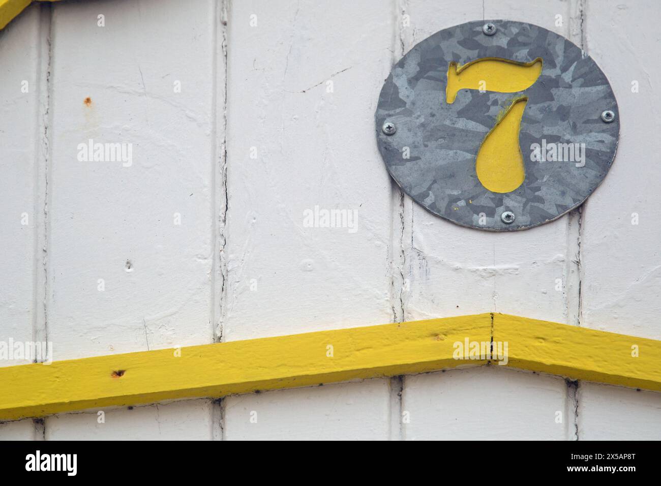 Great Yarmouth, Norfolk, Angleterre, avril 2024, gros plan photo d'un numéro 7 coloré peint en jaune sur une cabane de plage prise en format paysage Banque D'Images