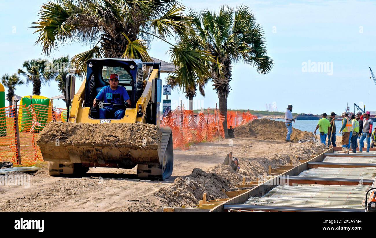 PORT ARANSAS, TX - 29 février 2020 : un ouvrier conduit une chargeuse frontale CAT 289D jaune pour déplacer une charge de terre sur un chantier près de l'eau. Banque D'Images