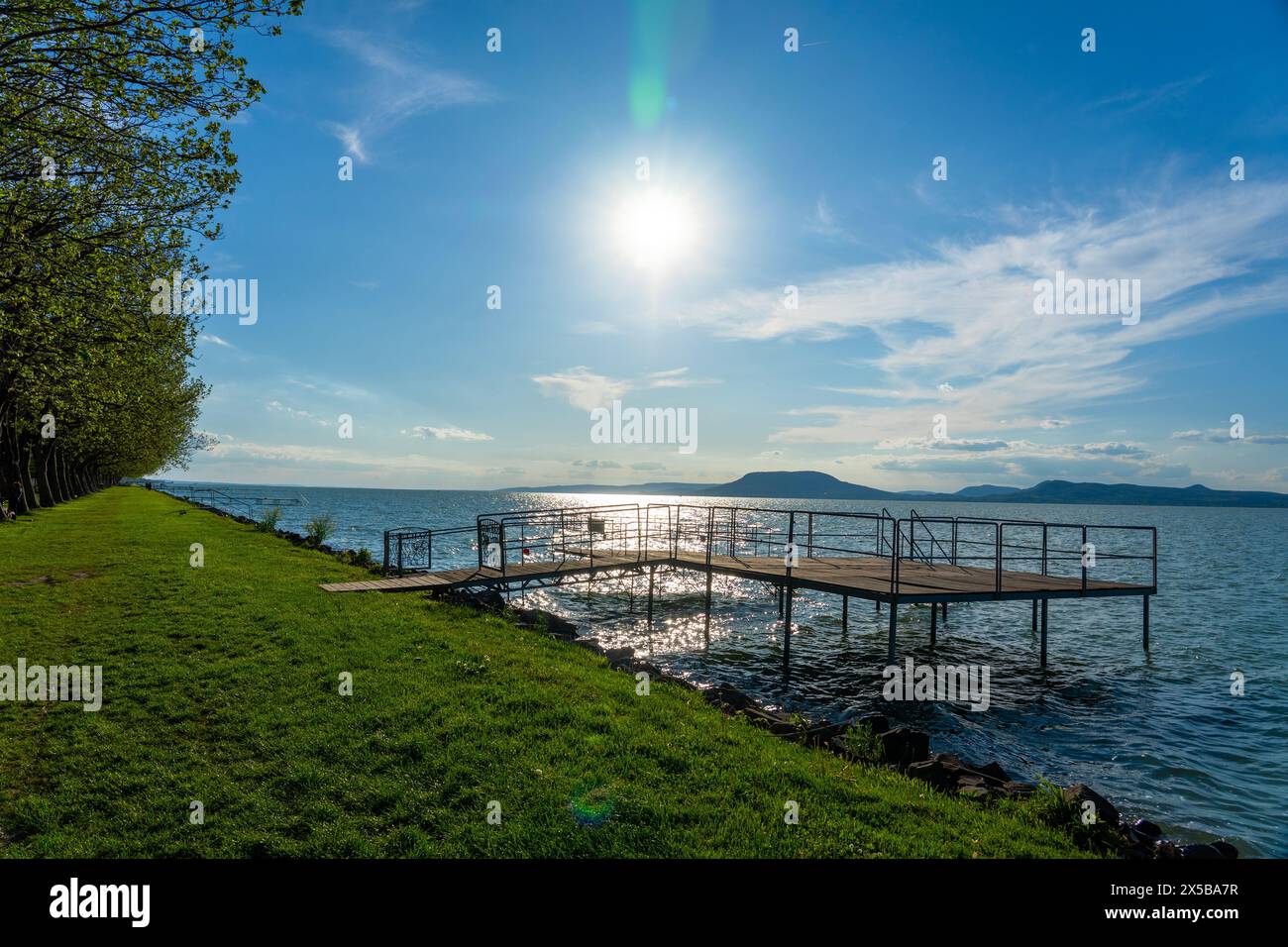 Plage libre sur le lac Balaton avec des arbres et la nature à Balatonboglar Hongrie avec une jetée en bois . Banque D'Images