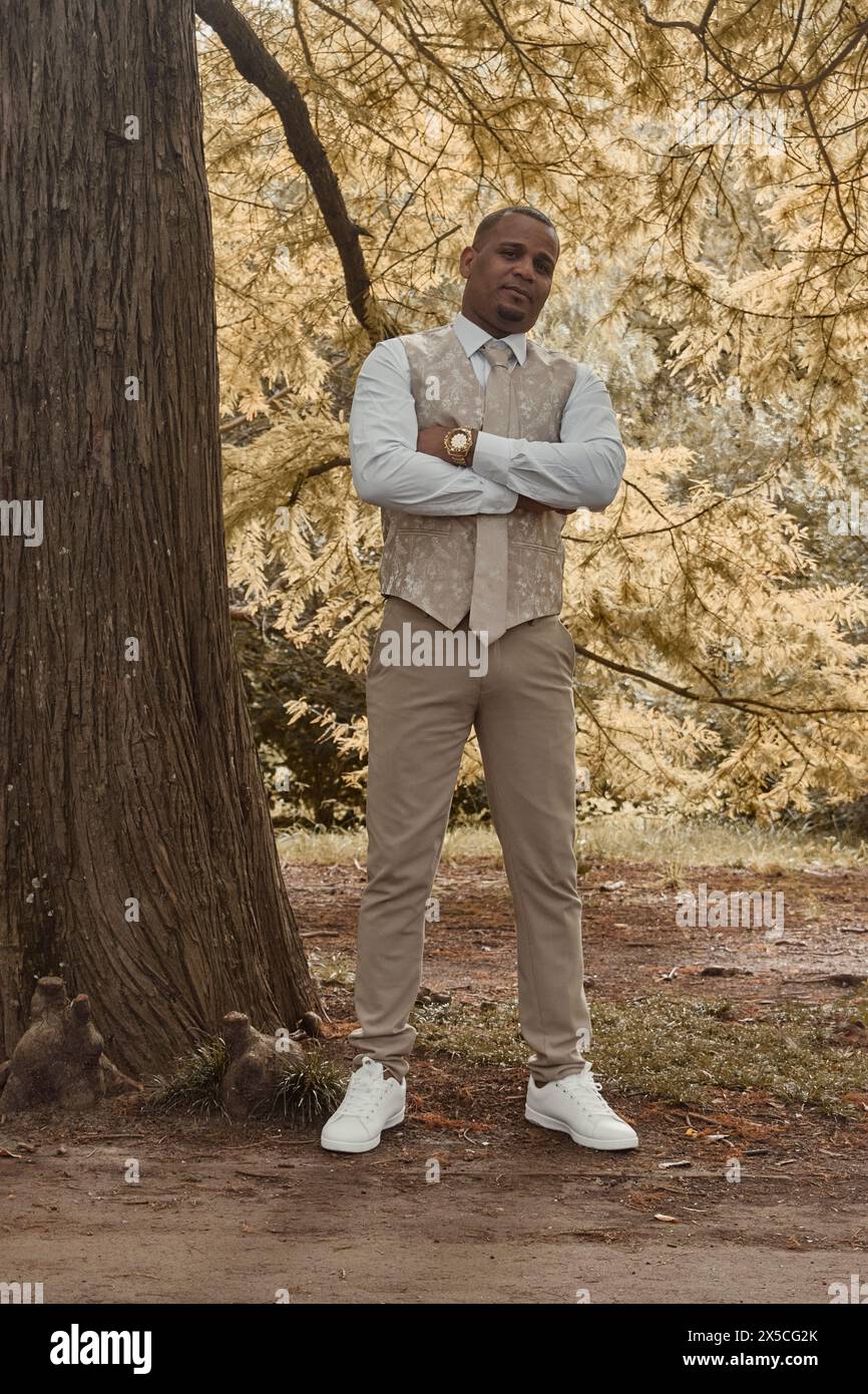 Homme latino-américain élégamment habillé avec bras croisés et montre en or. Concept d'automne Banque D'Images