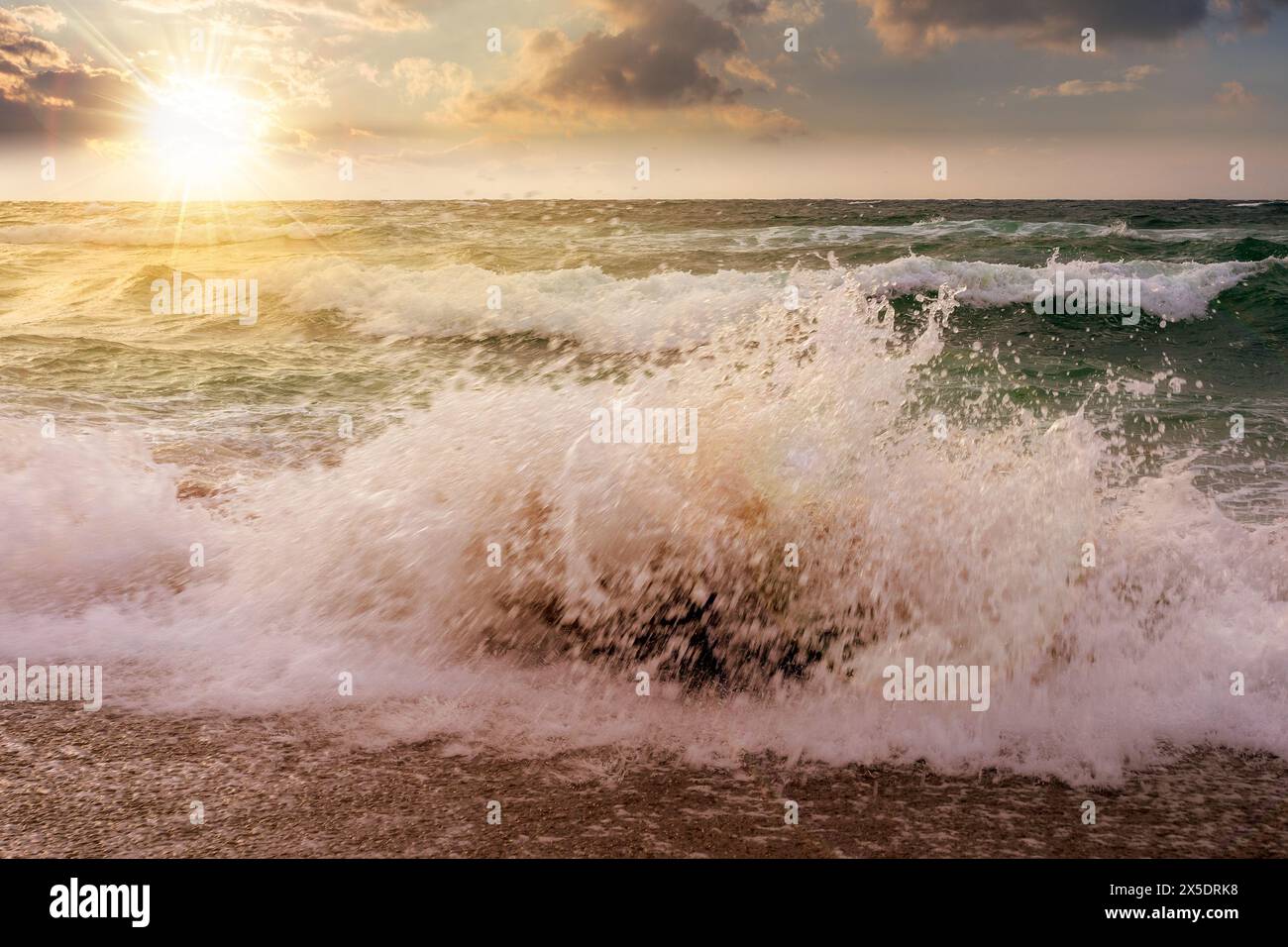 paysage marin spectaculaire au coucher du soleil. vagues se brisant sur la plage dans la lumière du soir Banque D'Images
