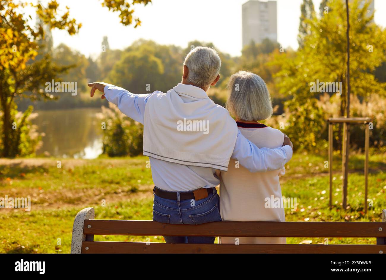 Couple senior romantique dans l'amour à la date parlant tout en étant assis sur le banc du parc. Banque D'Images