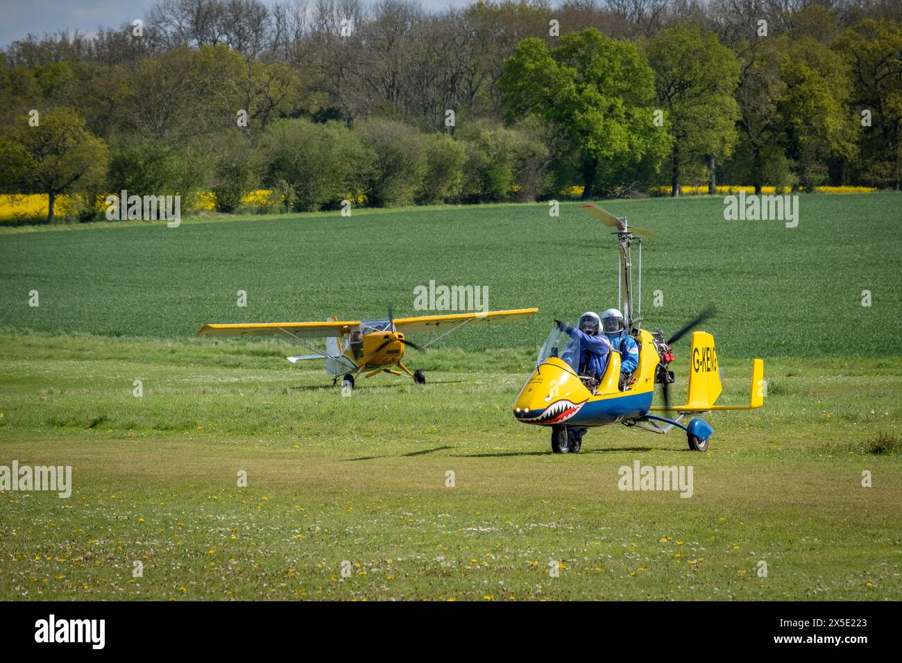 Un avion léger Sherwood Scout G-INYS atterrissant derrière un gyrocoptère jaune à la Foire commerciale Popham Microlight en mai 2024 dans le Hampshire, en Angleterre Banque D'Images