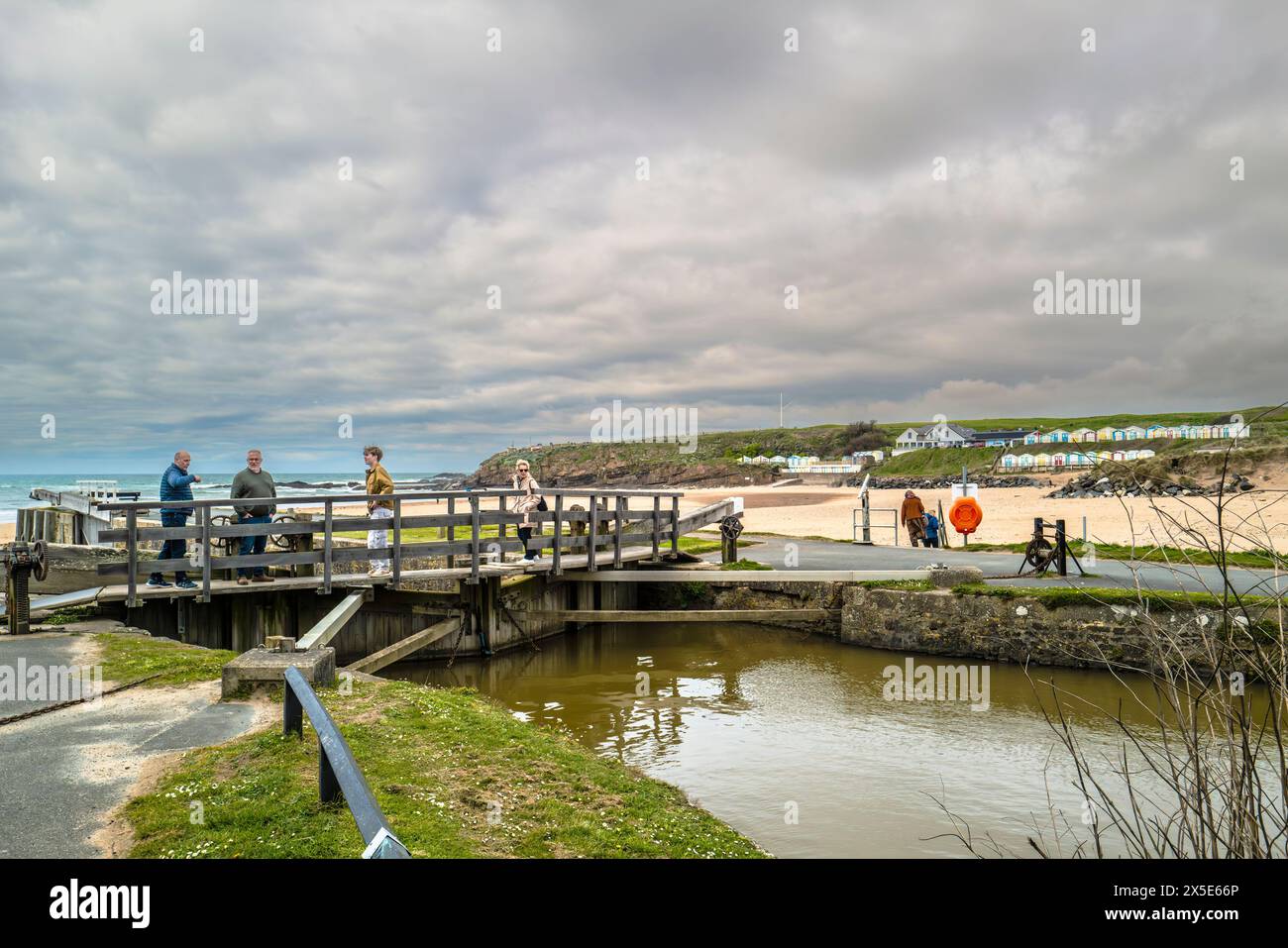 Personnes visiteurs debout sur les portes de l'écluse de mer sur le canal historique de Bude à Bude en Cornouailles au Royaume-Uni. Banque D'Images