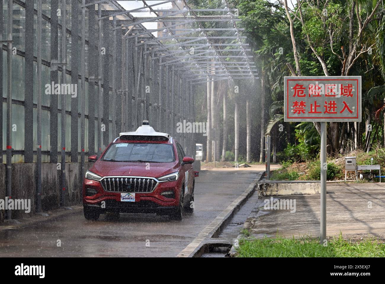 (240509) -- HAIKOU, 9 mai 2024 (Xinhua) -- Une voiture est en cours d'essai pour conduite autonome par temps pluvieux à Qionghai, dans la province de Hainan, dans le sud de la Chine, le 8 mai 2024. Le premier site d'essai automobile en Chine est à Qionghai City. Chaque année, des centaines de voitures sont transportées ici pour être testées avant d’arriver sur le marché. Le site d'essai couvre une superficie de 1 200 mu (80 hectares), avec des routes à grande vitesse, des champs d'exposition et d'autres installations, qui peuvent effectuer divers tests et évaluations tels que la fiabilité du véhicule, la durabilité et la conduite assistée intelligente. (Xinhua/Guo Cheng) Banque D'Images