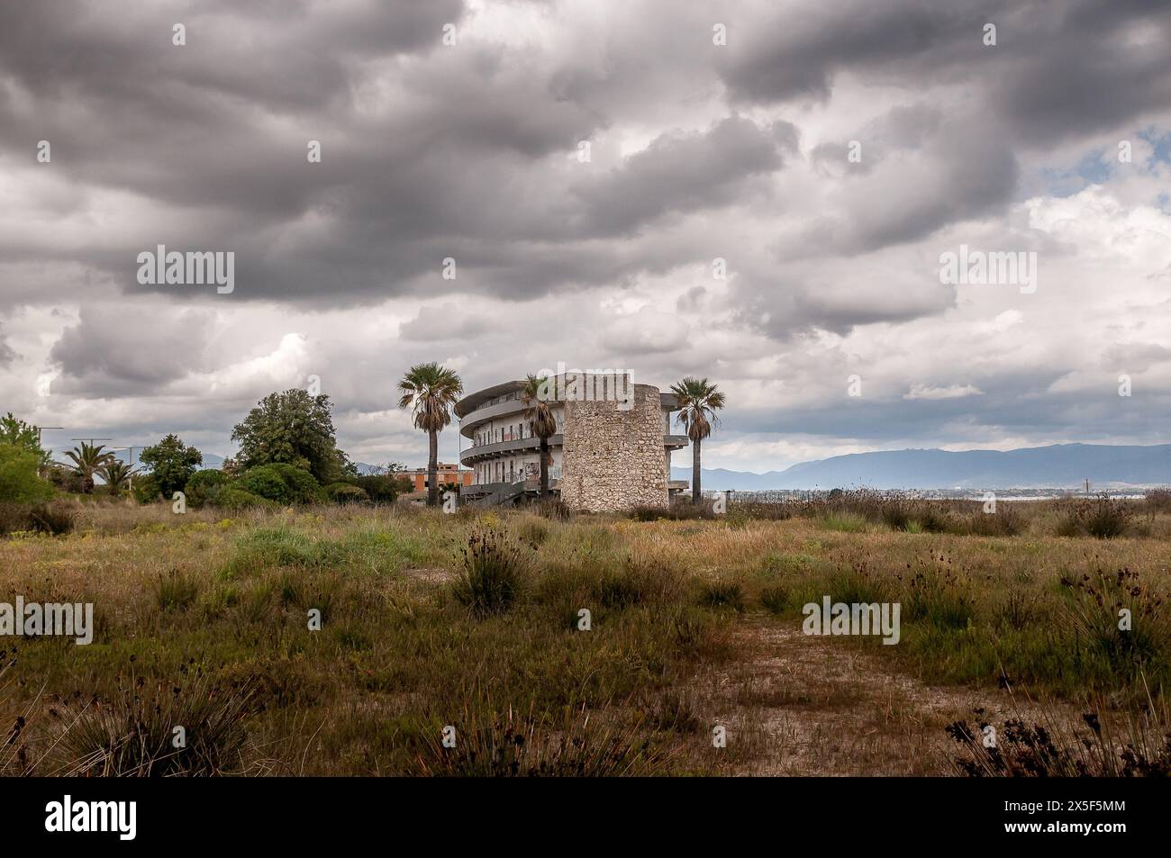 Ancien hôpital abandonné et ancienne tour de guet à Cagliari, Sardaigne, sous un ciel dramatique Banque D'Images