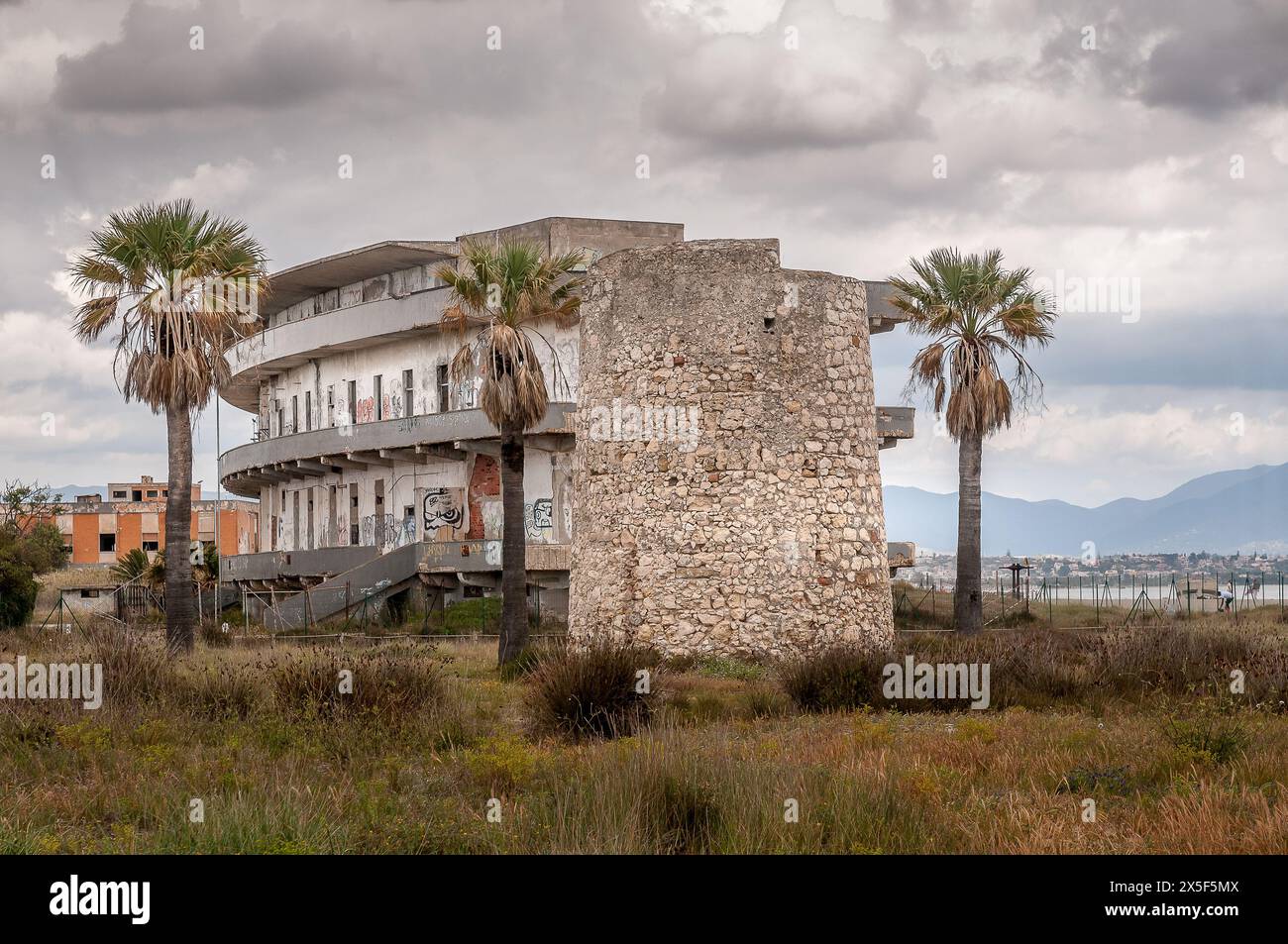 Ancien hôpital abandonné et ancienne tour de guet à Cagliari, Sardaigne, sous un ciel dramatique Banque D'Images
