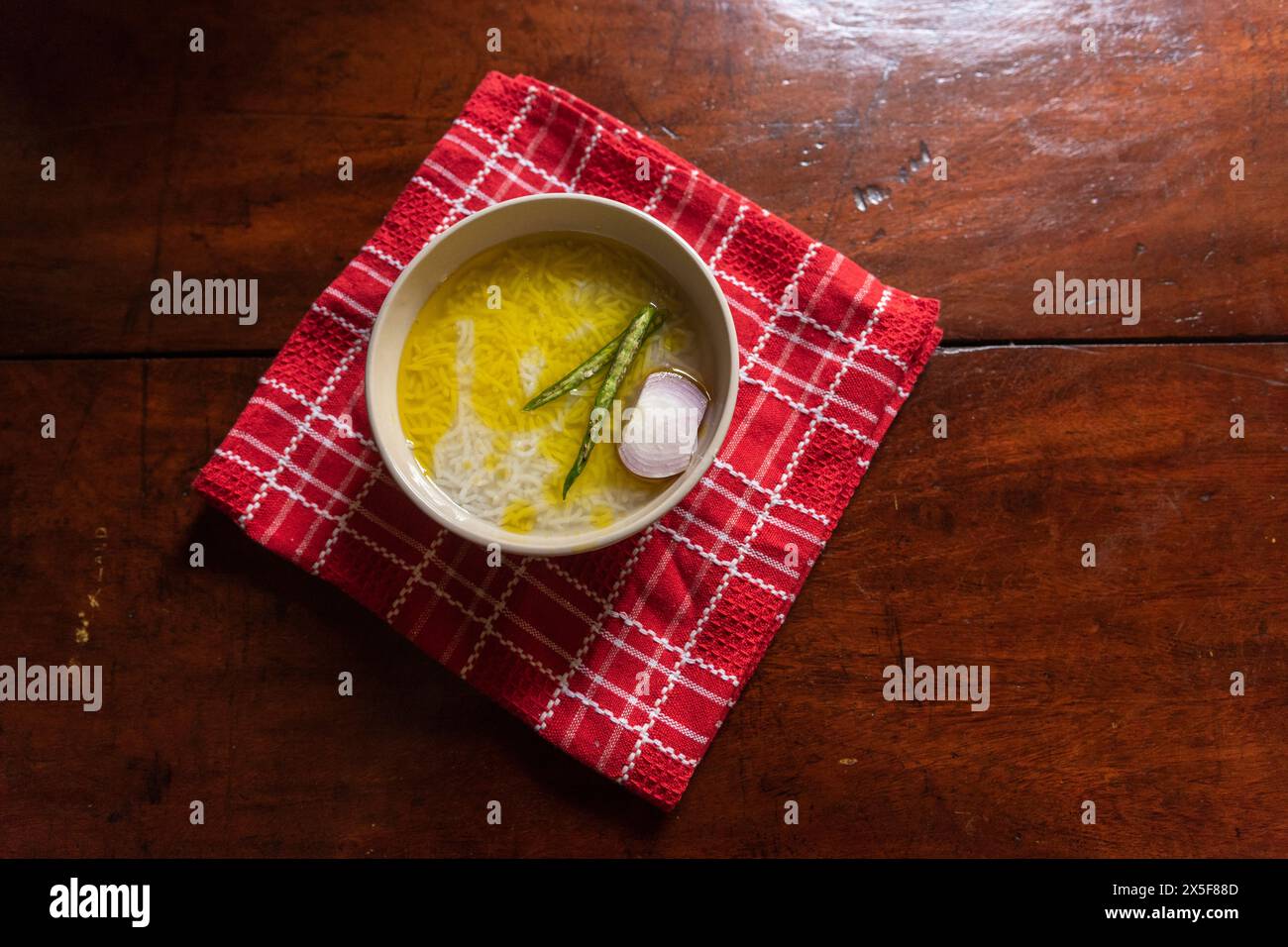 Panta bhat ou pakhala ou soupe de riz fermenté avec de l'eau, des piments verts et de l'oignon dans un bol. Aliments de base dans l'est de l'Inde. Banque D'Images