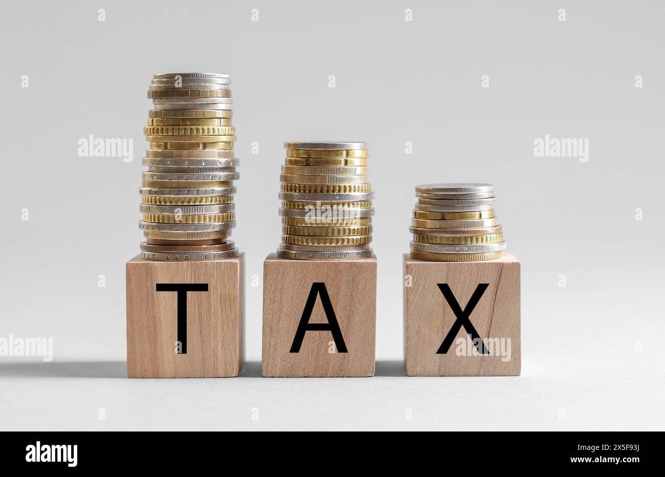 Word Tax fait de cubes et de pièces de monnaie en bois sur fond blanc, espace pour le texte Banque D'Images