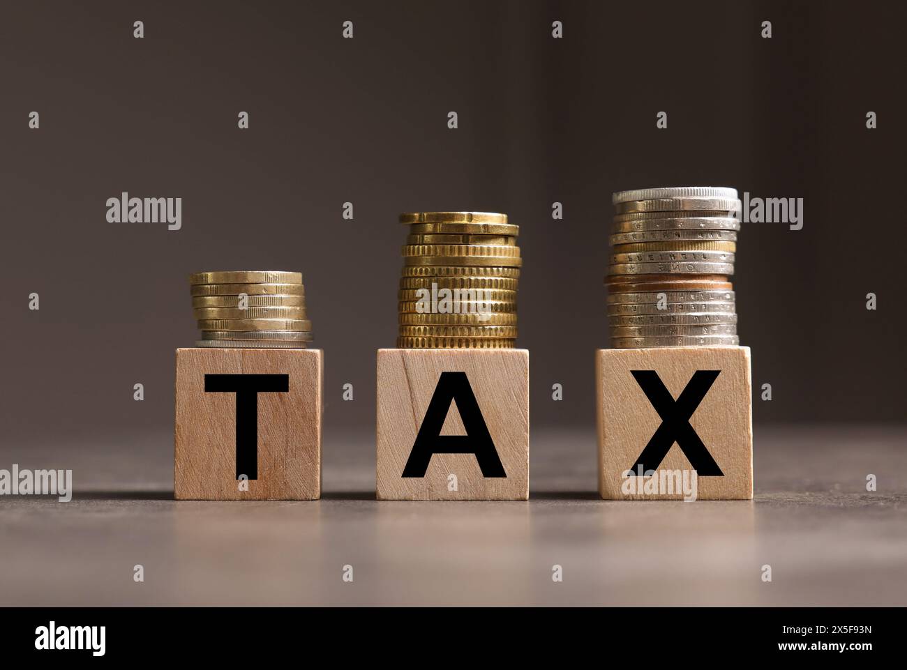 Word Tax fait de lettres et de pièces de monnaie en bois sur une table grise, espace pour le texte Banque D'Images