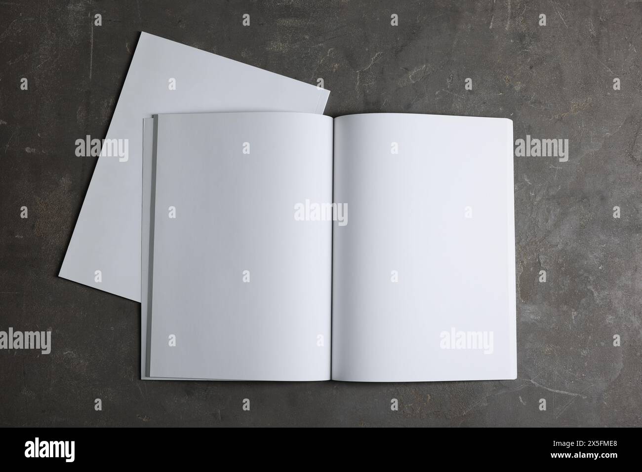 Ouvrez le carnet avec des feuilles de papier vierges sur fond texturé gris, vue de dessus. Maquette pour le design Banque D'Images