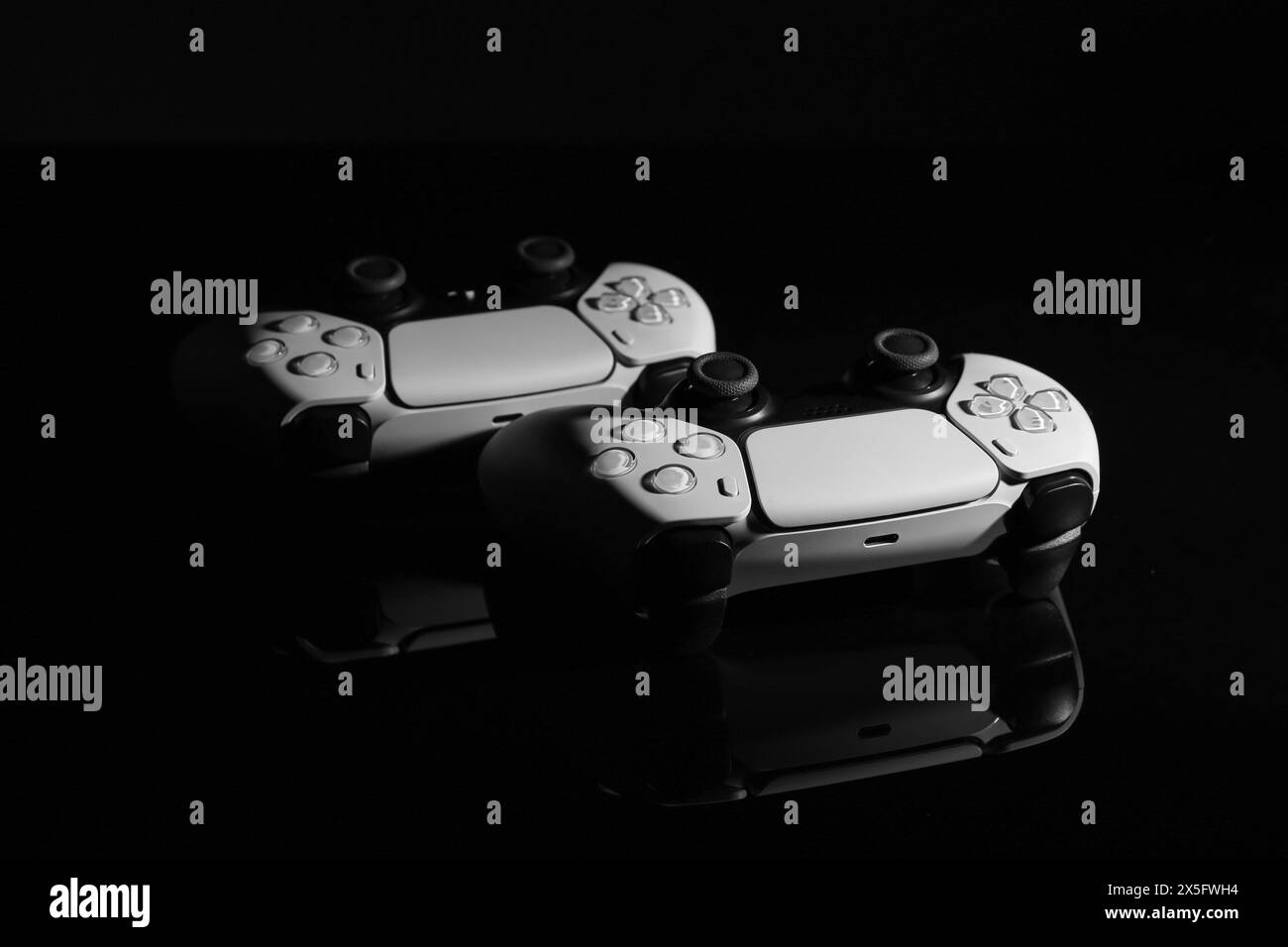Manettes de jeu sans fil sur surface miroir noire Banque D'Images