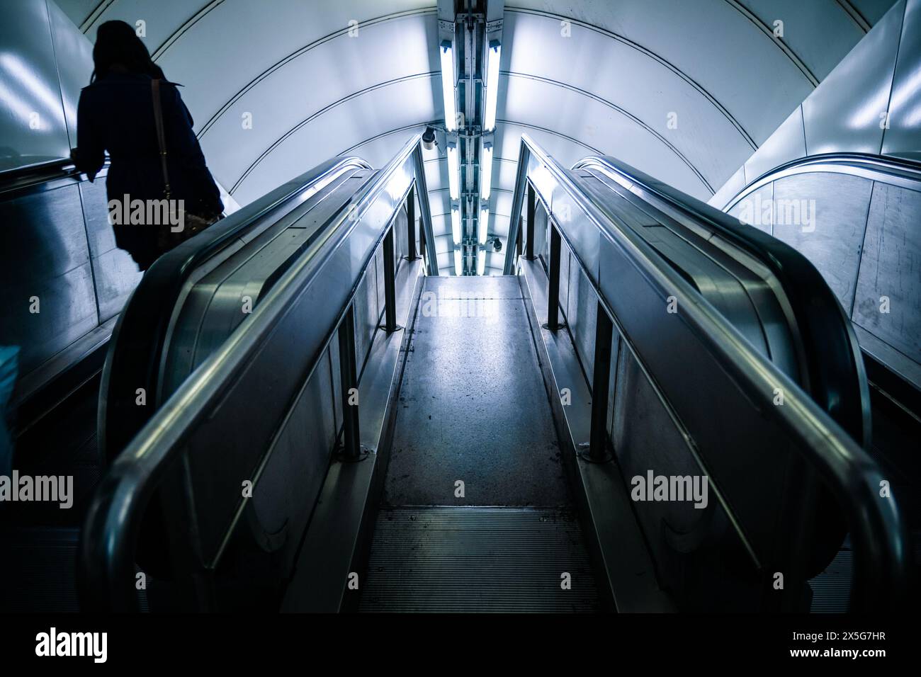 Femme dans l'escalator souterrain de Londres Banque D'Images