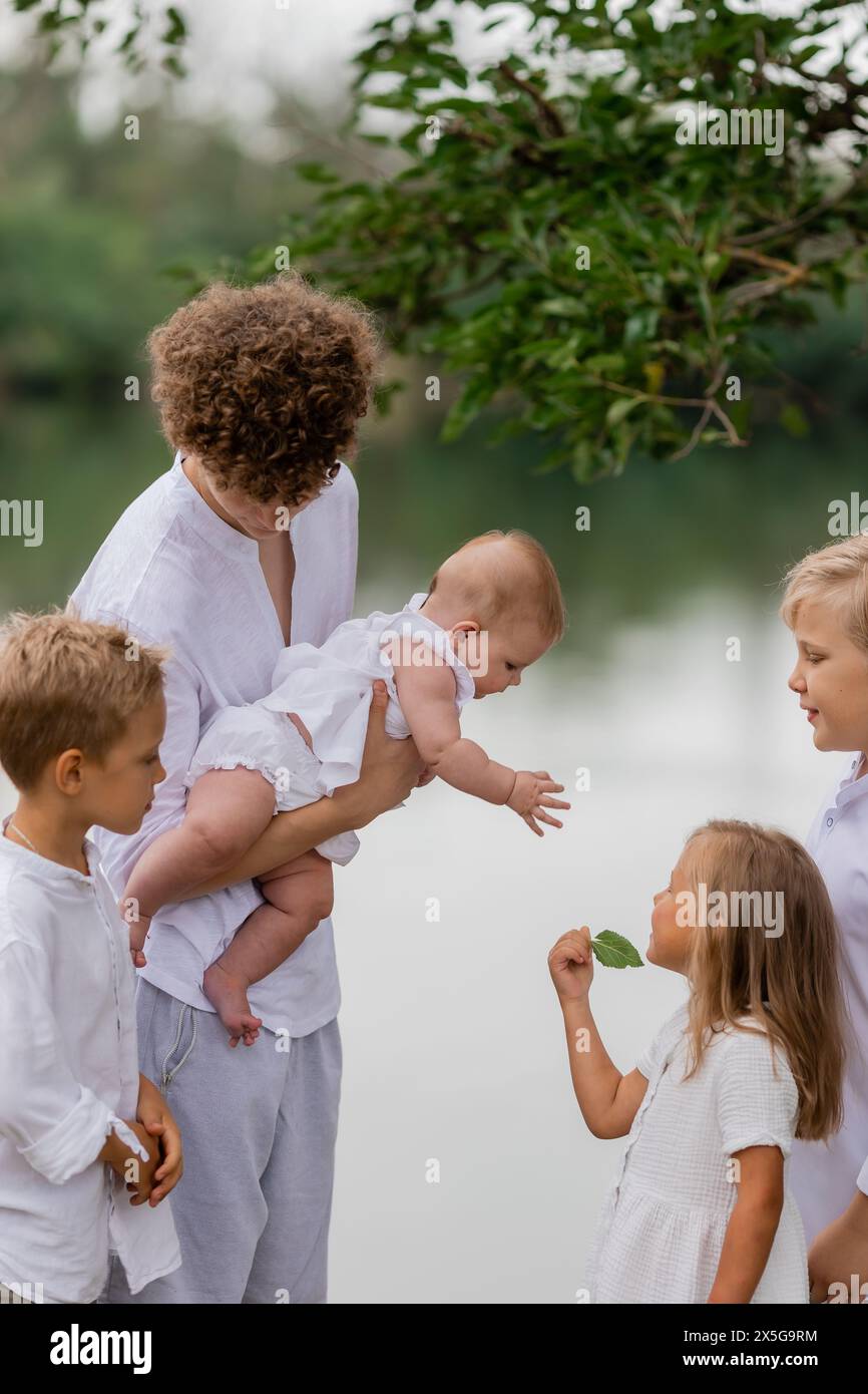 enfants, frères et sœurs marchent près du lac en été, une grande famille. Photo de haute qualité Banque D'Images