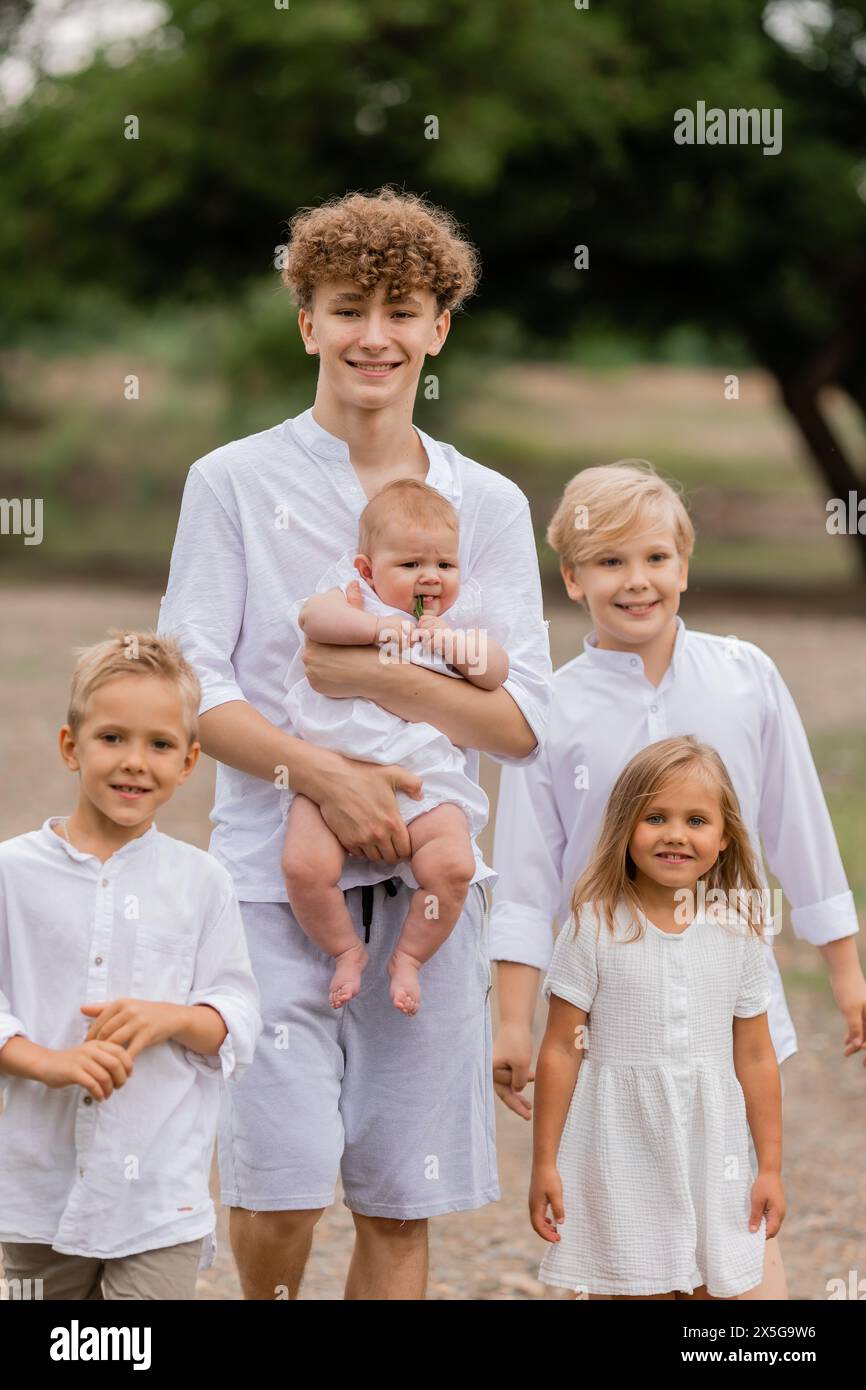 enfants, frères et sœurs marchent près du lac en été, une grande famille. Photo de haute qualité Banque D'Images