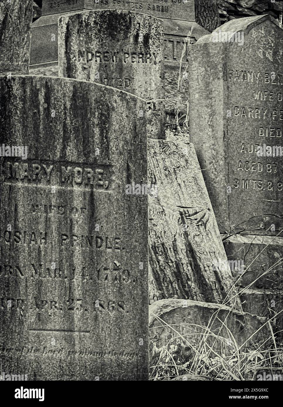 Une photographie en noir et blanc d'une collection de pierres tombales vieilles et érodées, certaines à peine lisibles, retrouvées dans un cimetière datant de 1720 Banque D'Images