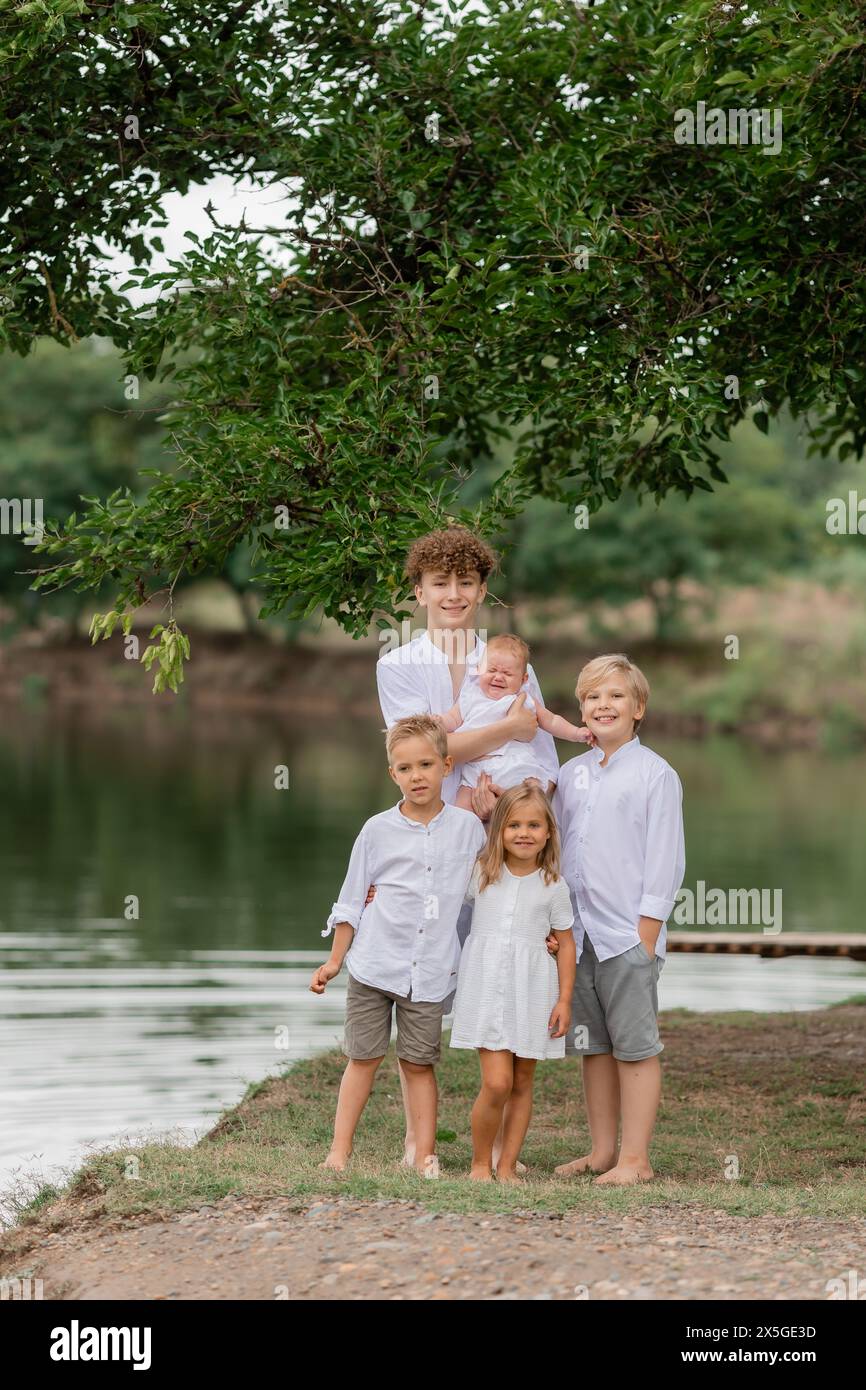 enfants, frères et sœurs marchent près du lac en été, une grande famille Banque D'Images