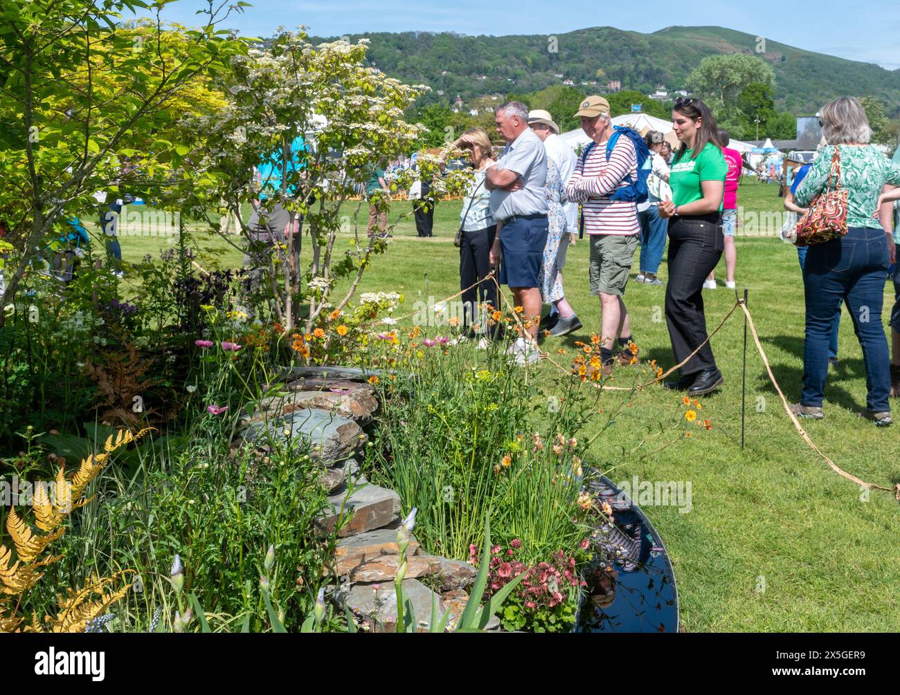 9 mai 2024. RHS Malvern Spring Festival a ouvert aujourd'hui par une chaude journée ensoleillée. Des milliers de visiteurs ont assisté à l'exposition florale annuelle au Three Counties Showground à Malvern, Worcestershire, Angleterre, Royaume-Uni. L'événement se déroule sur 4 jours, se terminant le 12 mai 2024. Sur la photo : les gens admirant le jardin de l'héritage Macmillan conçu par Kerianne Fitzpatrick & TJ Kennedy, l'un des jardins d'exposition. Banque D'Images