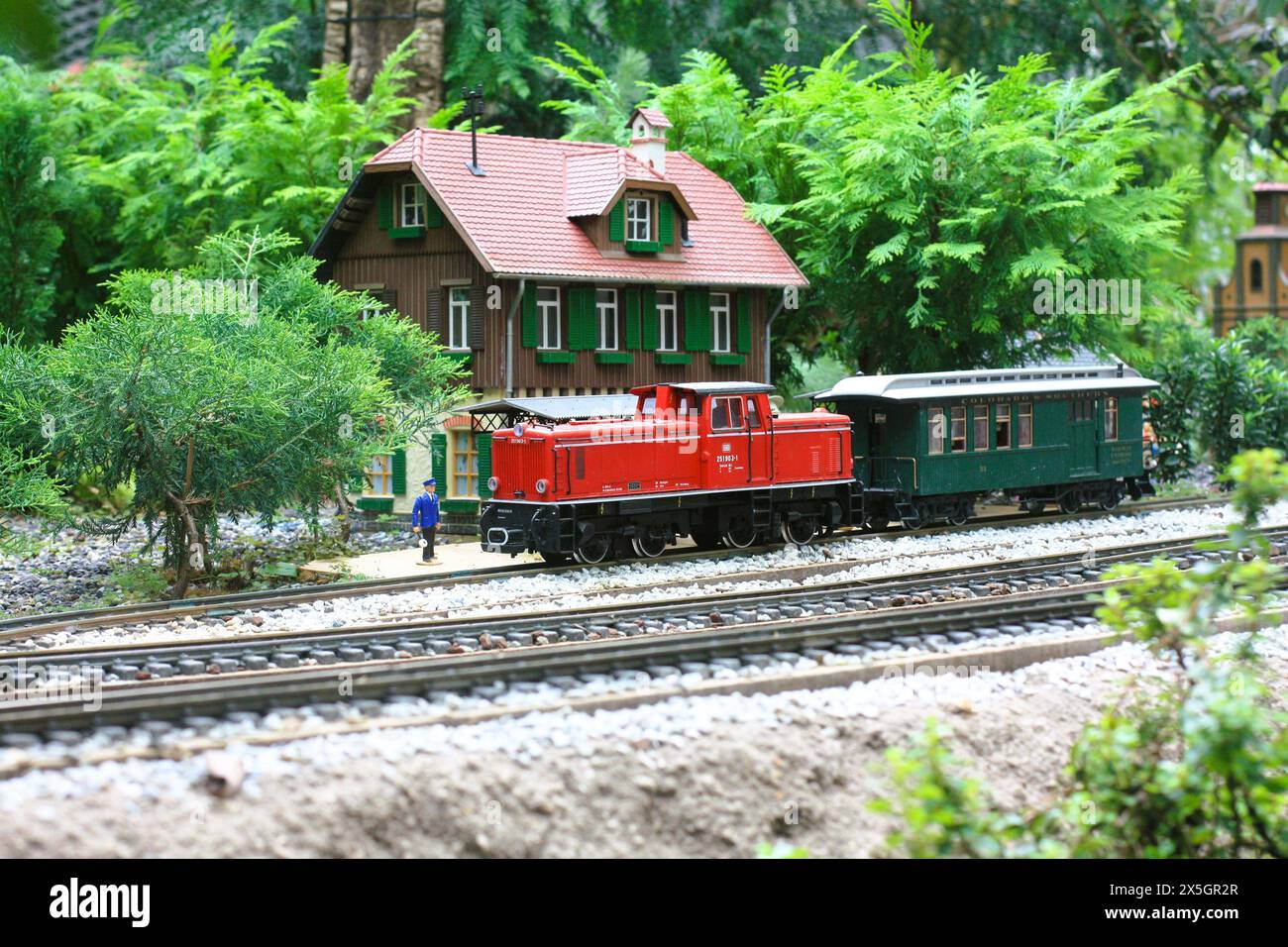 un ensemble de train modèle avec une maison modèle en arrière-plan. Banque D'Images