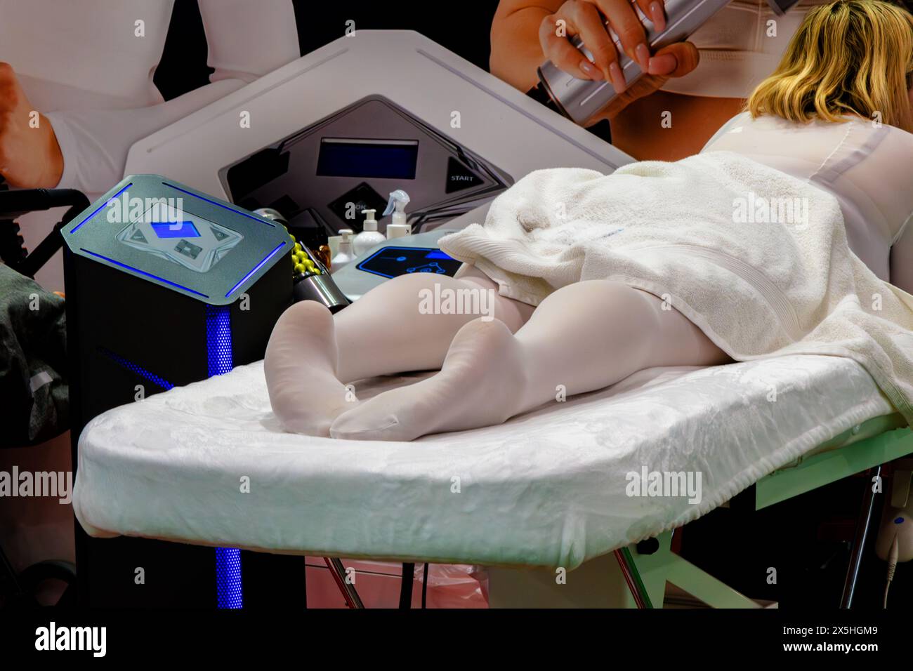 Femme allongée sur un canapé dans un salon de beauté. Elle porte des bas blancs et une serviette. Une femme attend des procédures esthétiques Banque D'Images