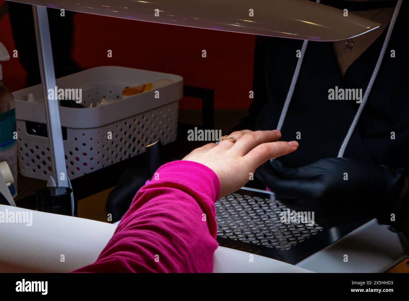 Un maquilleur fait une manucure sur les ongles de son client Banque D'Images