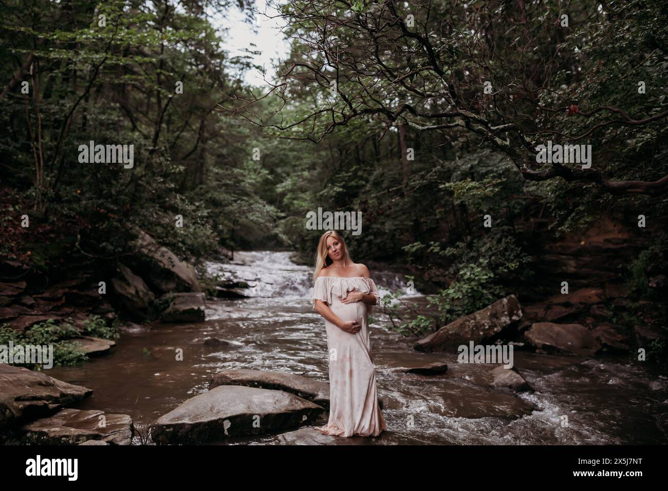 Femme enceinte troisième trimestre debout dans la rivière Banque D'Images