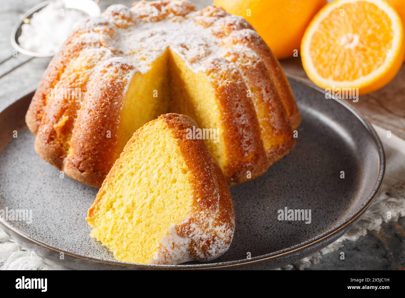 Gâteau de livre d'orange humide avec zeste d'orange gros plan sur une assiette sur la table. Horizontal Banque D'Images