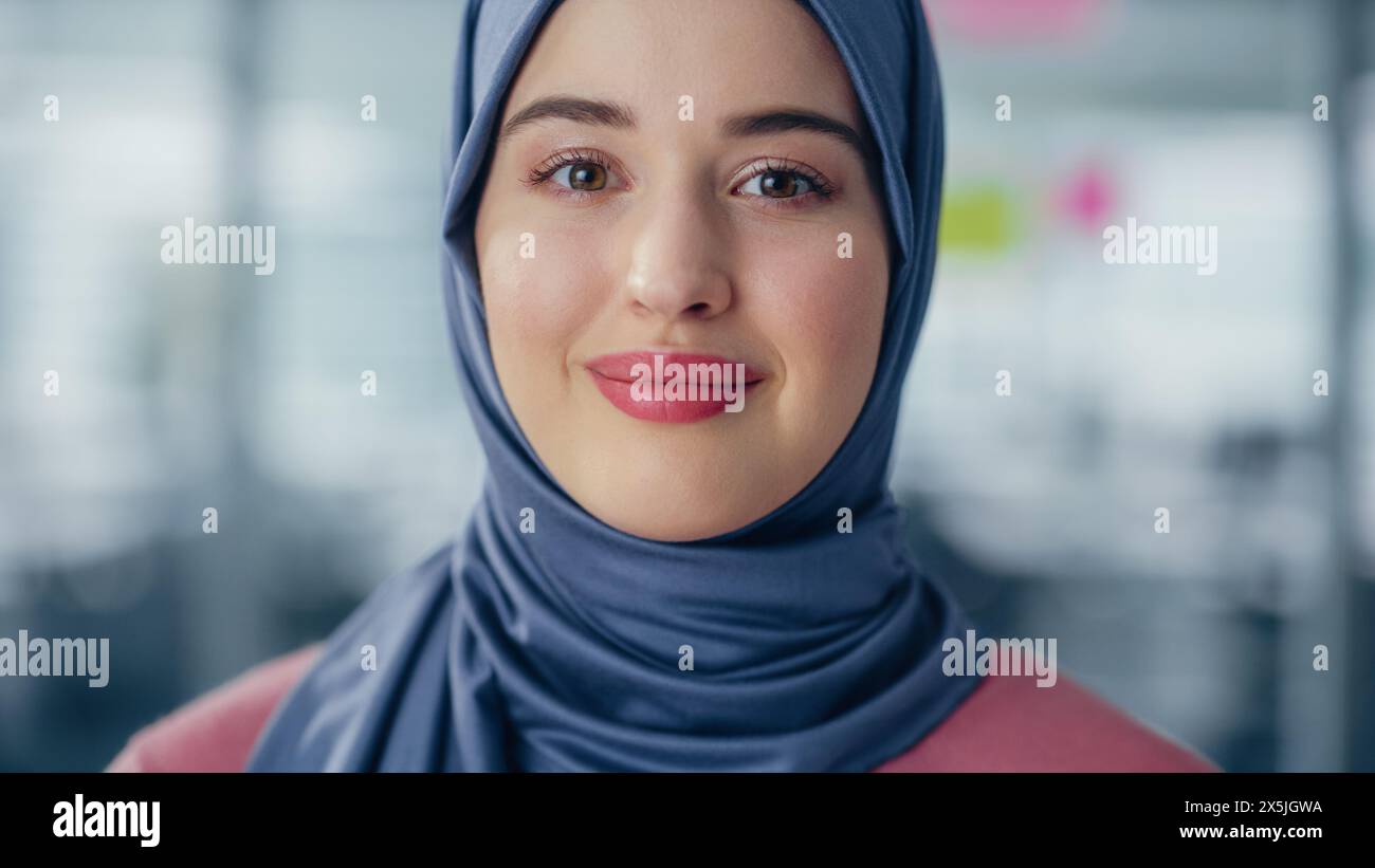 Gros plan Portrait d'une femme d'affaires musulmane portant le Hijab regarde caméra et sourires. Belle femme portant un foulard traditionnel. Femme arabe autonomisée réussie. Banque D'Images