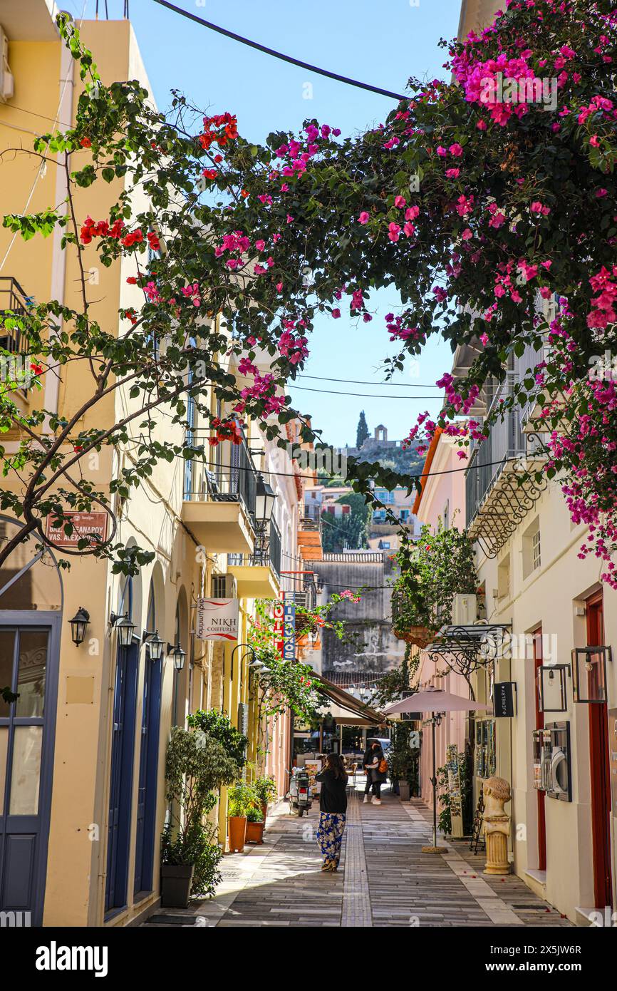 Nauplie, Grèce. Vieille ville rue pavée et village commerçant avec portes bleues et rouges et bougainvilliers roses. (Usage éditorial uniquement) Banque D'Images