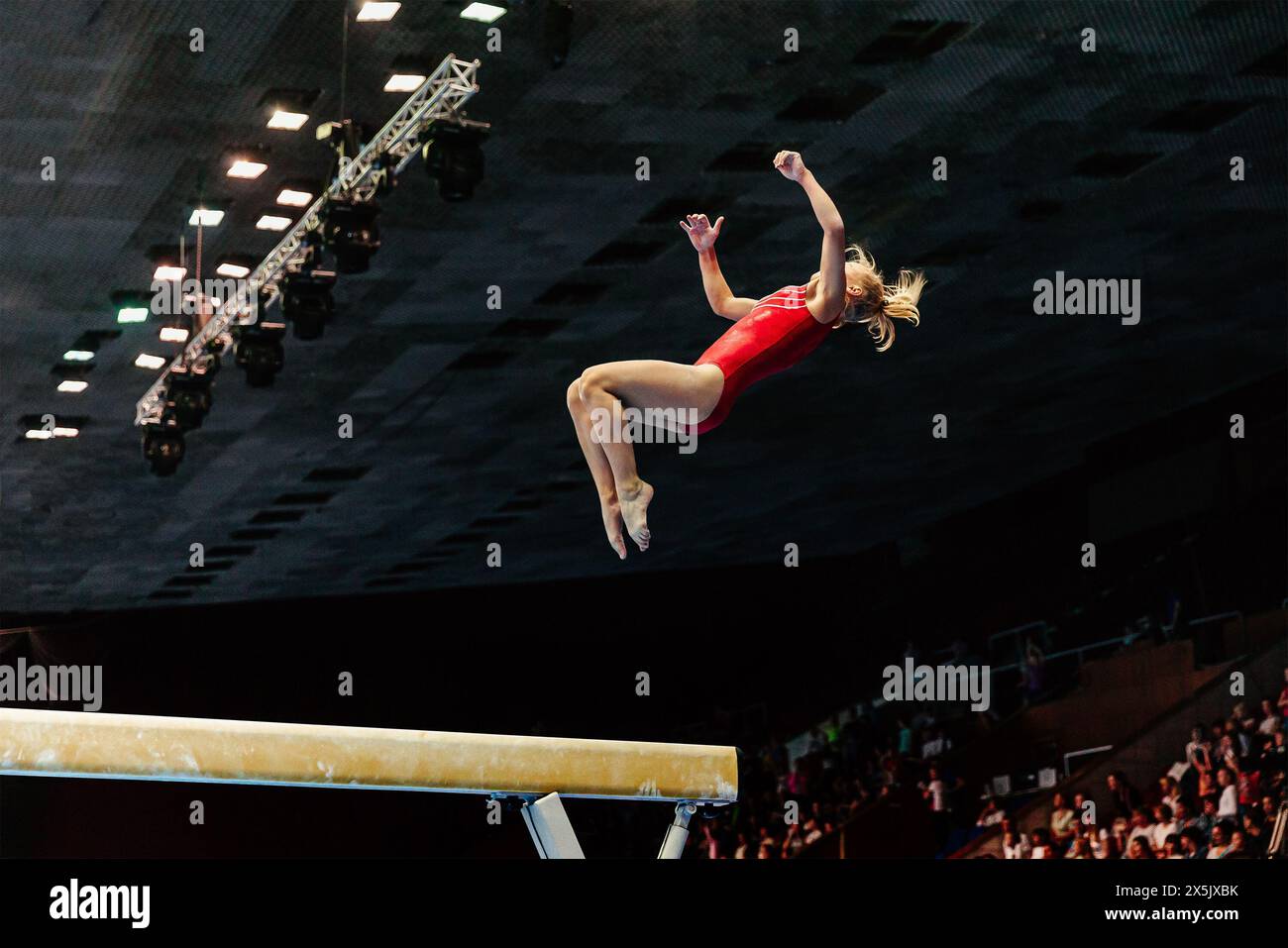 exercice sur la gymnastique de poutre d'équilibre, gymnaste féminine effectuer l'atterrissage de somersault en arrière sur le sol Banque D'Images